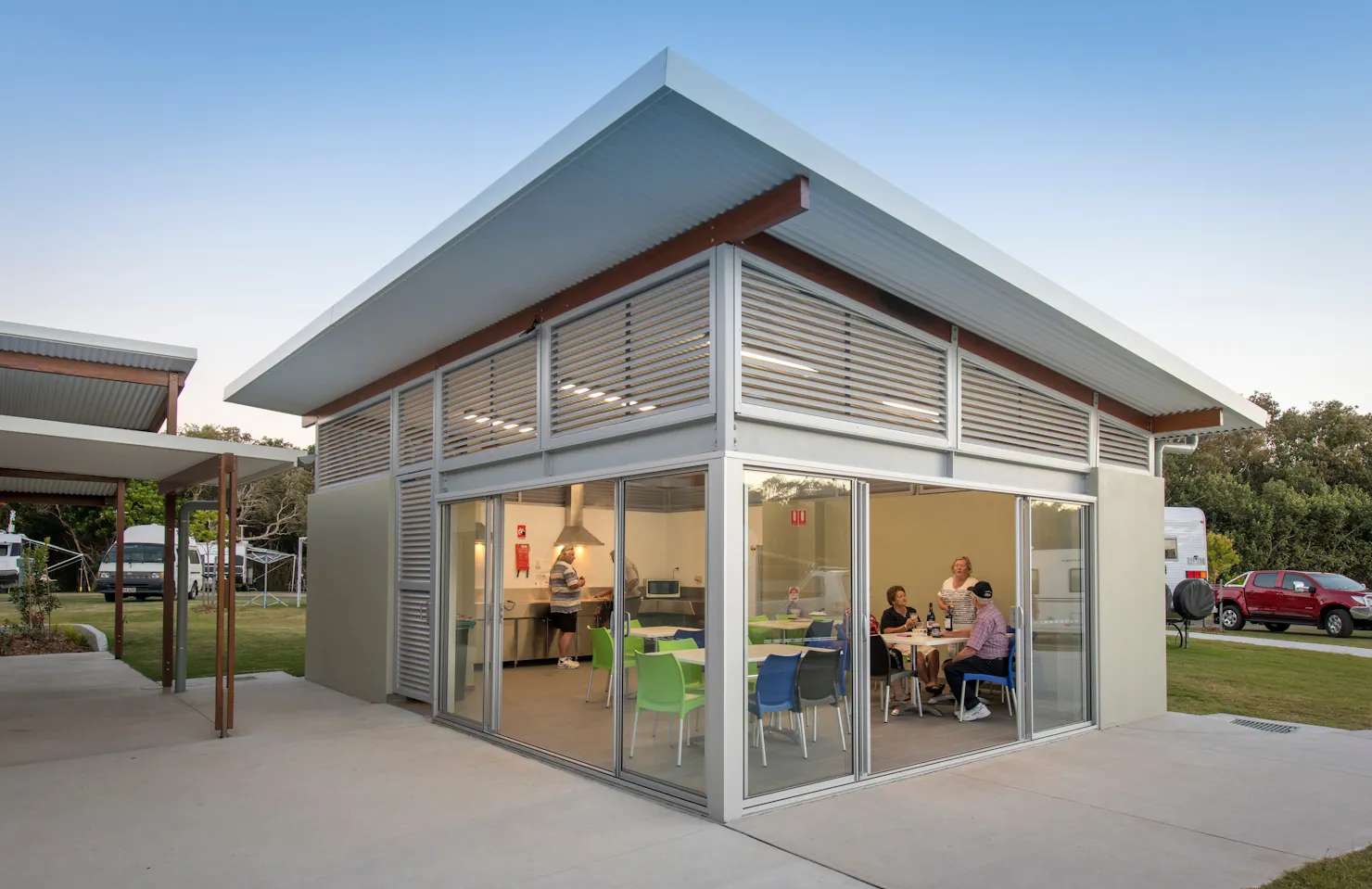 Shot of Mudjimba Beach Holiday Park camp kitchen with people drinking beer and cooking