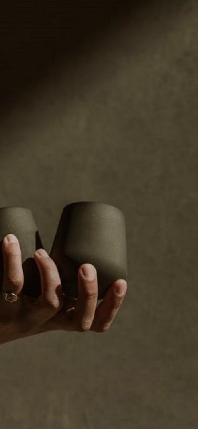 A hand holding 2 ceramic tumblers by Madeline Cardone (STUDIO VESSL)