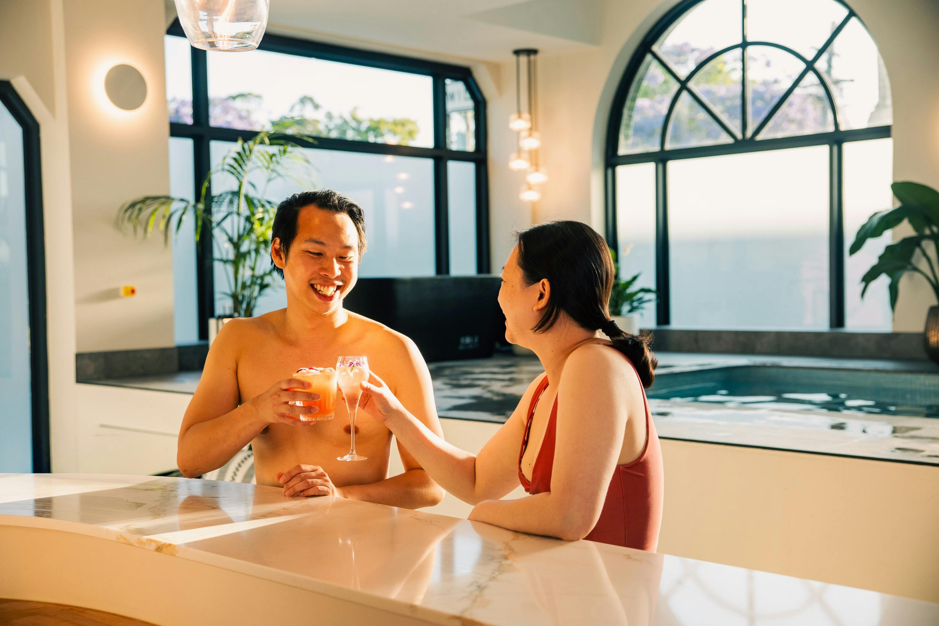 Two people relaxing by the Palacebo bar, enjoying a refreshing drink