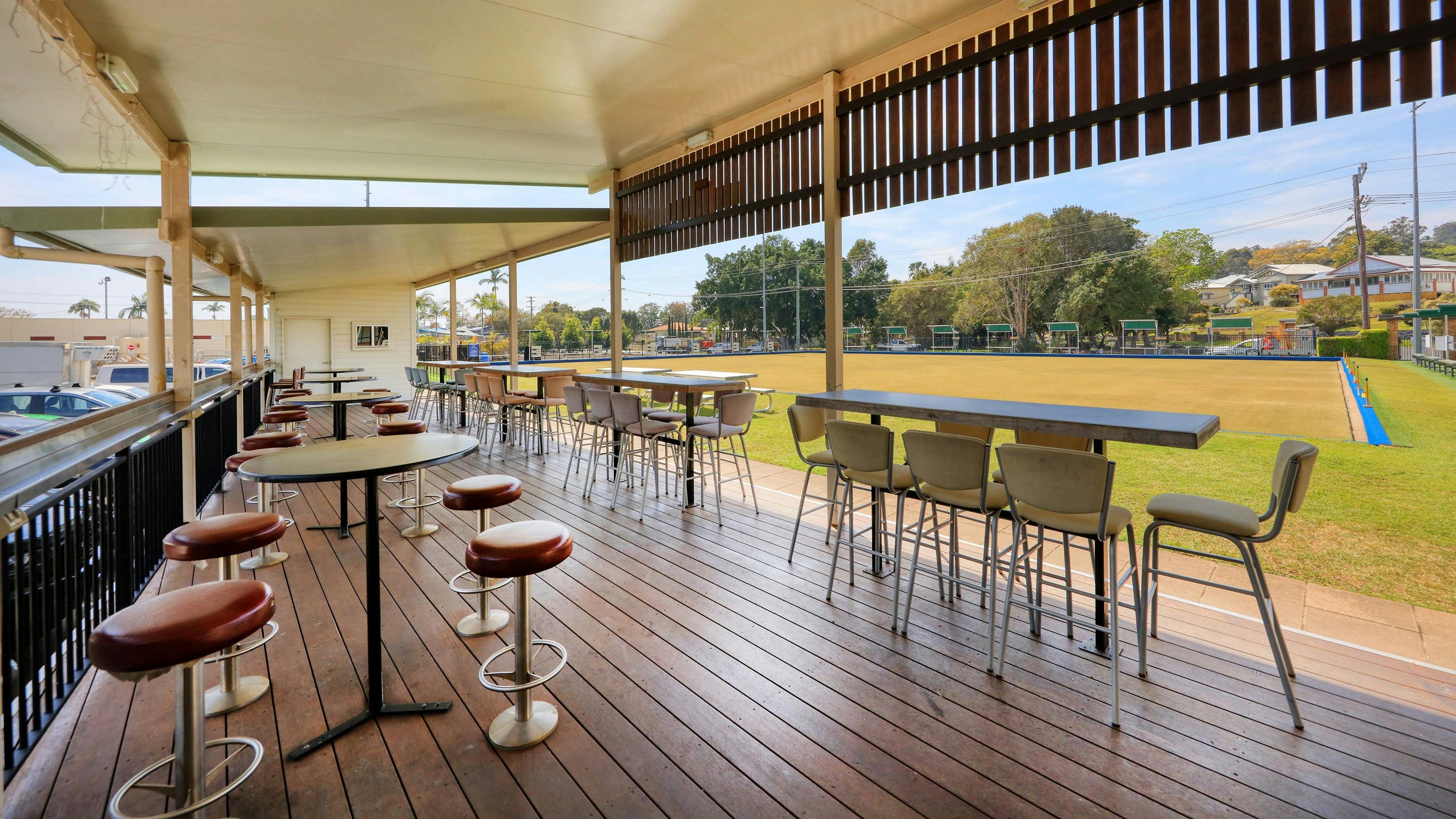 Covered outdoor seating area with outdoor bar right next to Club's two greens + kids playground area
