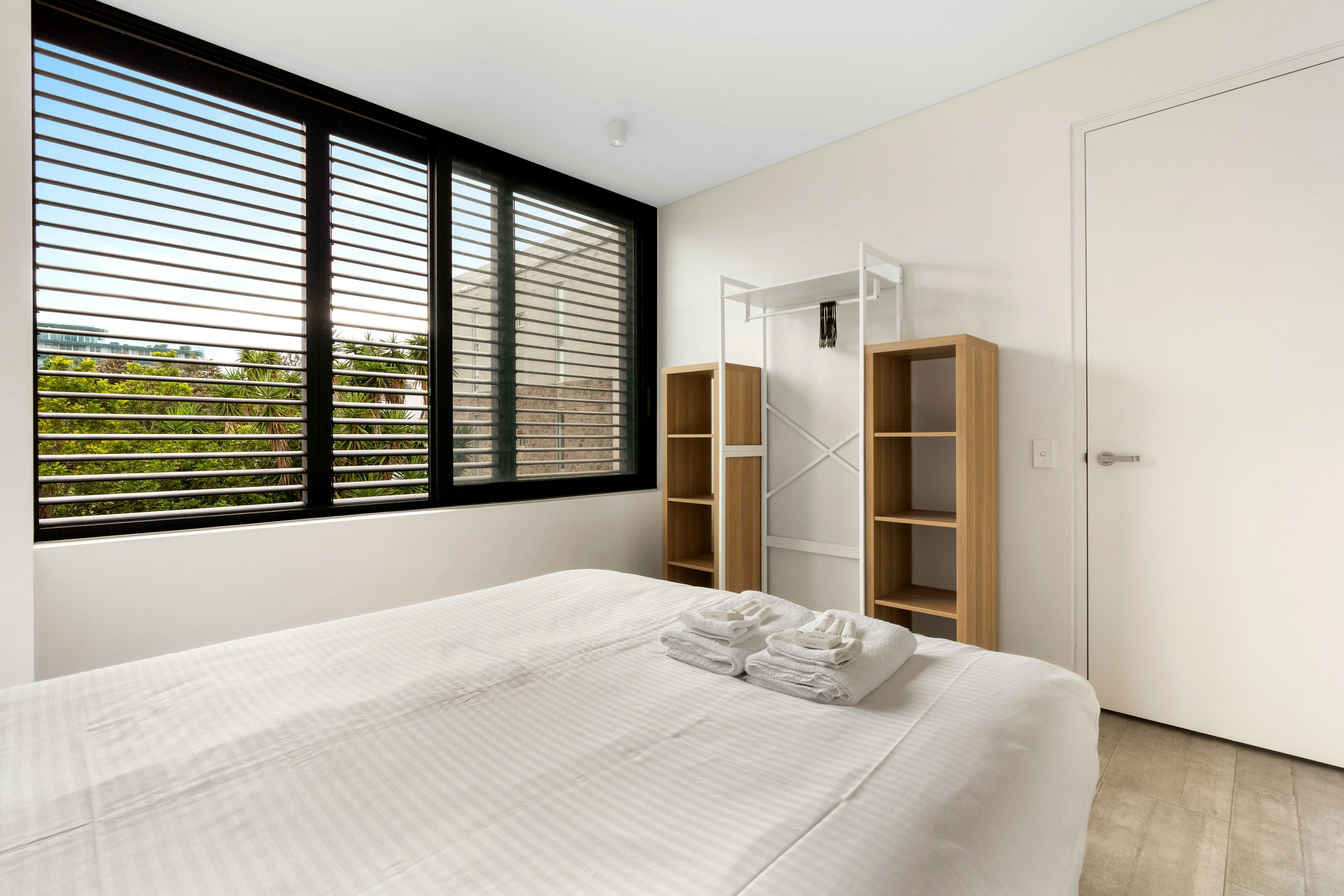 舒适的卧室，配有大窗户和舒适的床上用品。