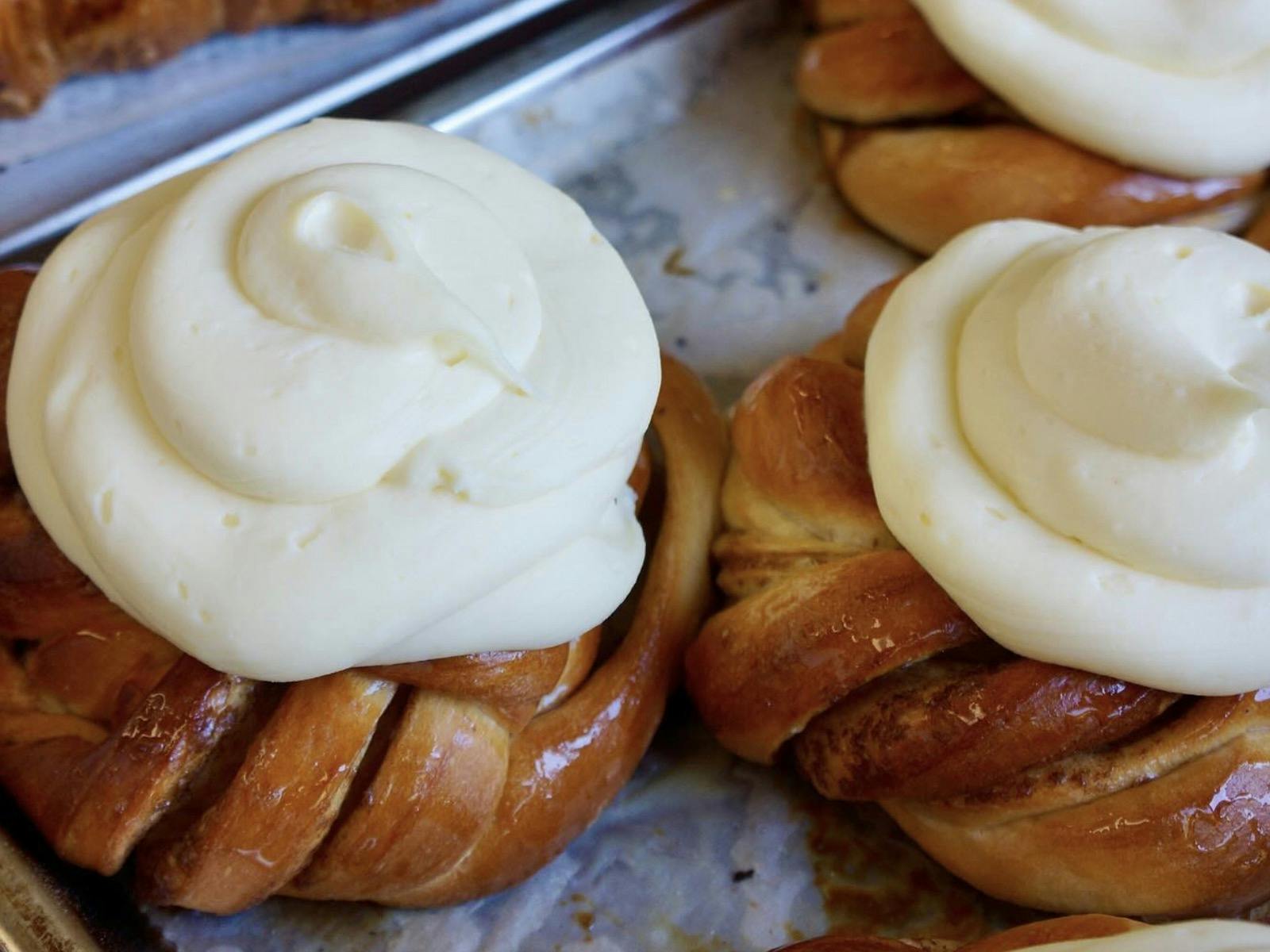 Babka style dough with brown sugar and cinnamon, topped with cream cheese icing, on an oven tray