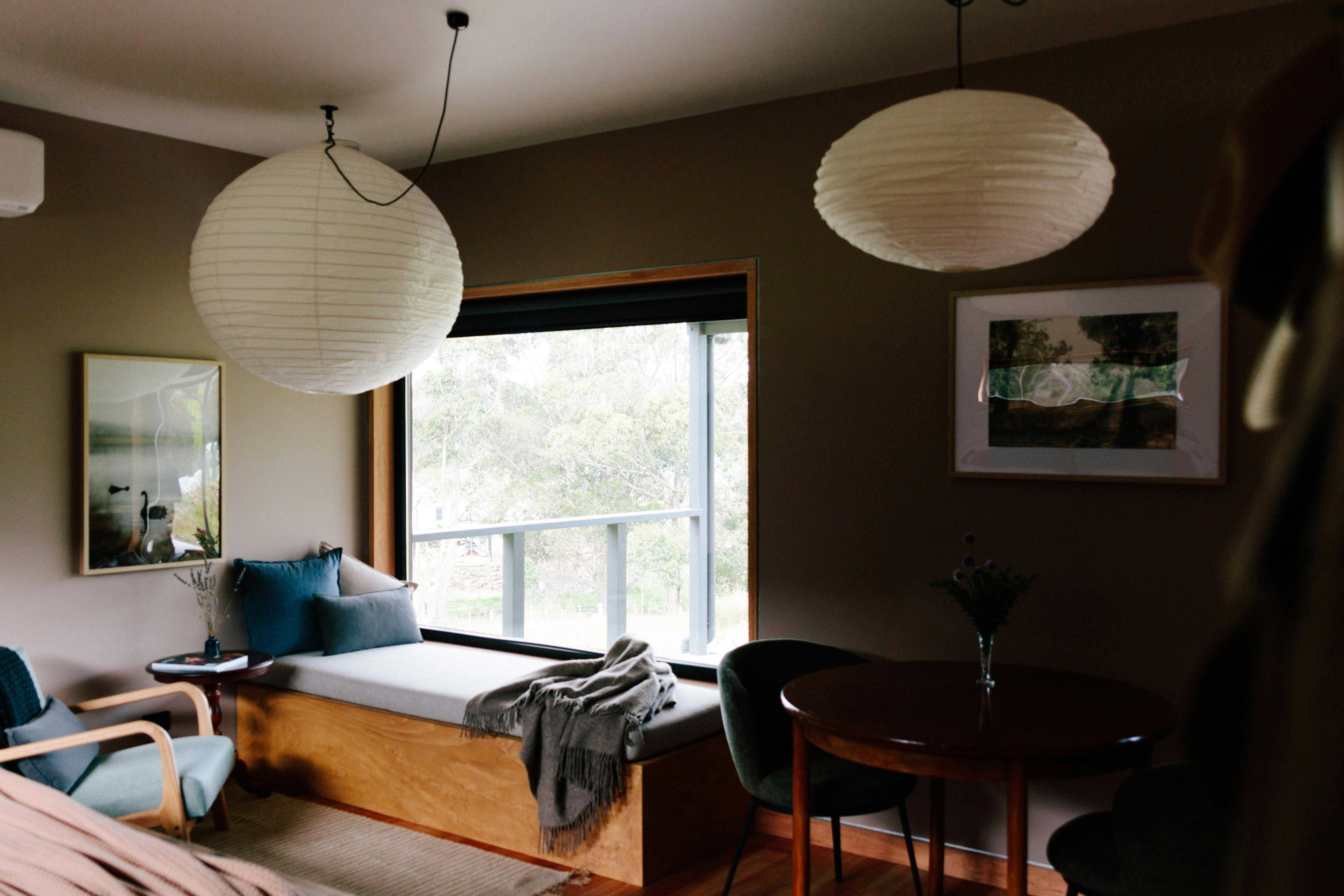 A living area with a window seat, occasional chair and dining table.