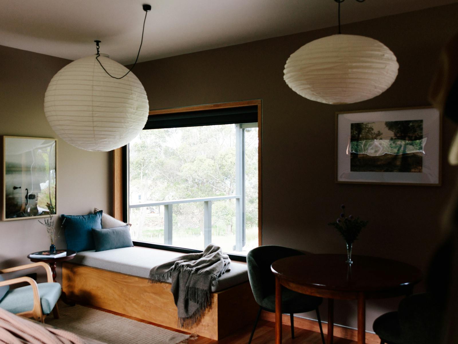 A living area with a window seat, occasional chair and dining table.