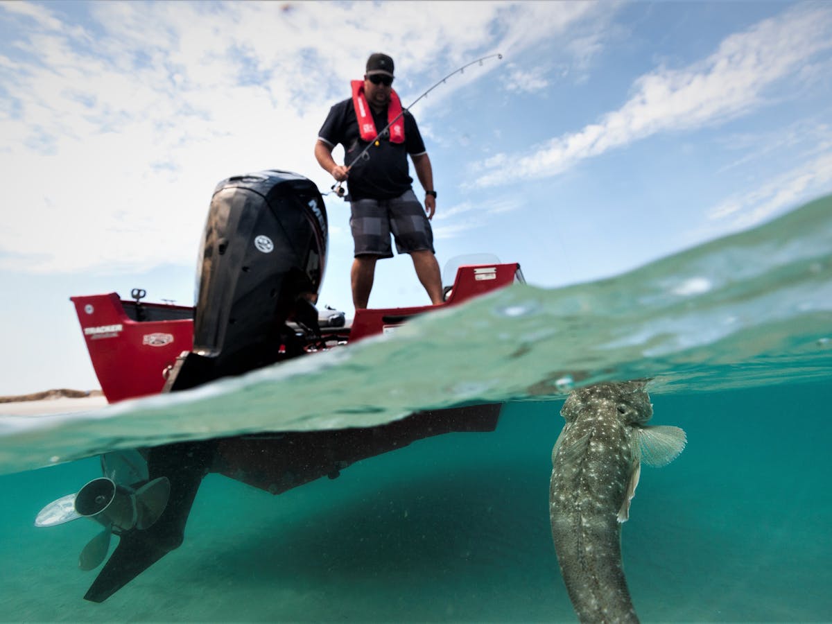 photo showing man fishing for flathead from a small boat on the great sandy strait