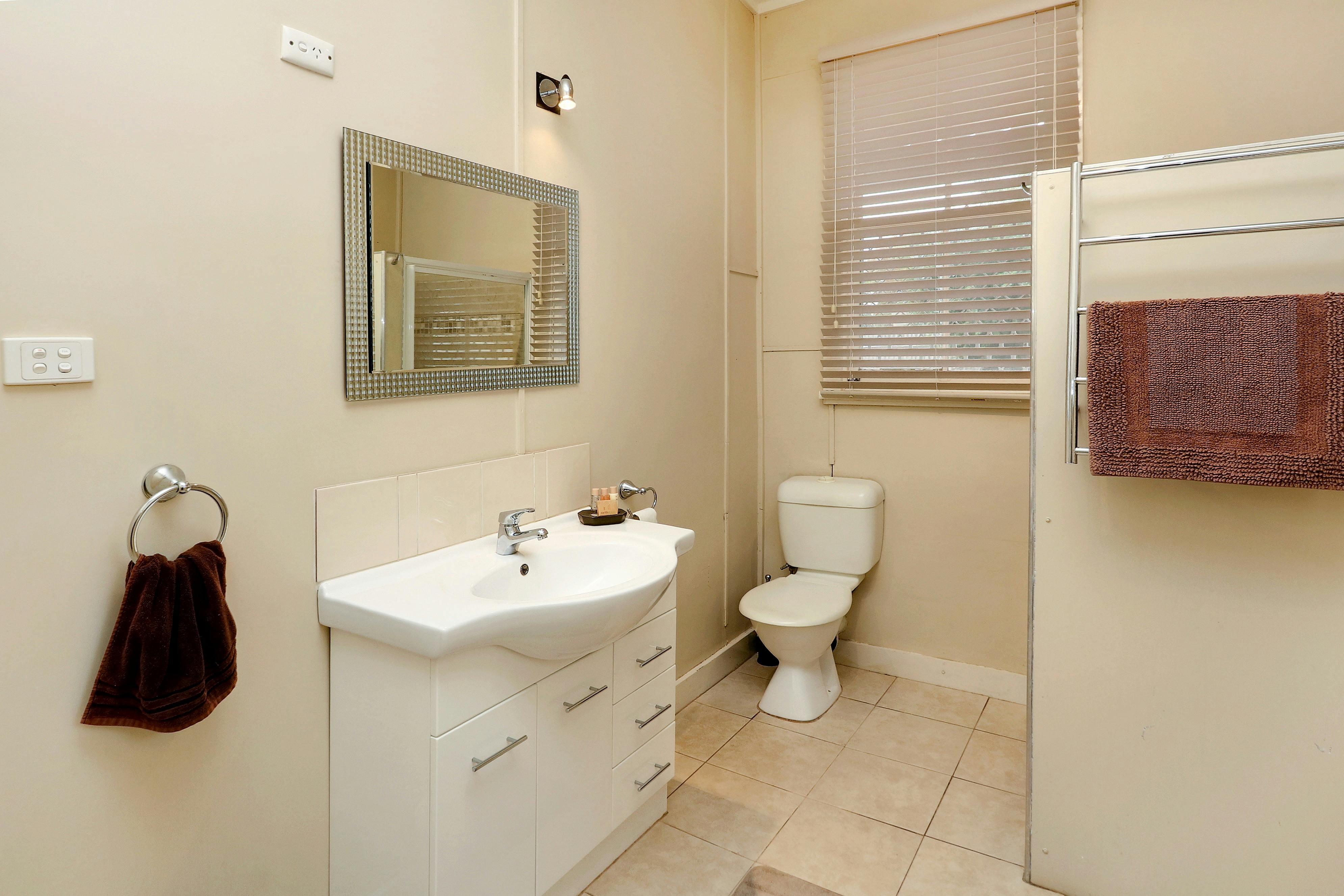 Featuring a shower, toilet, basin, washing machine and clothes rack.