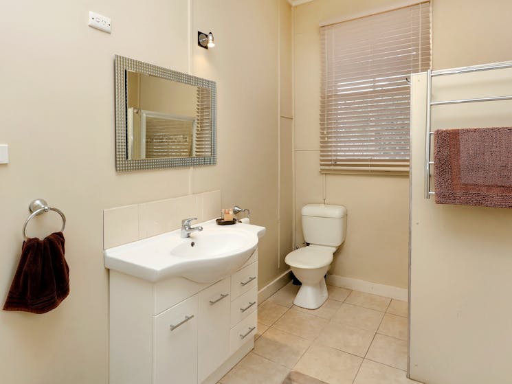 Featuring a shower, toilet, basin, washing machine and clothes rack.