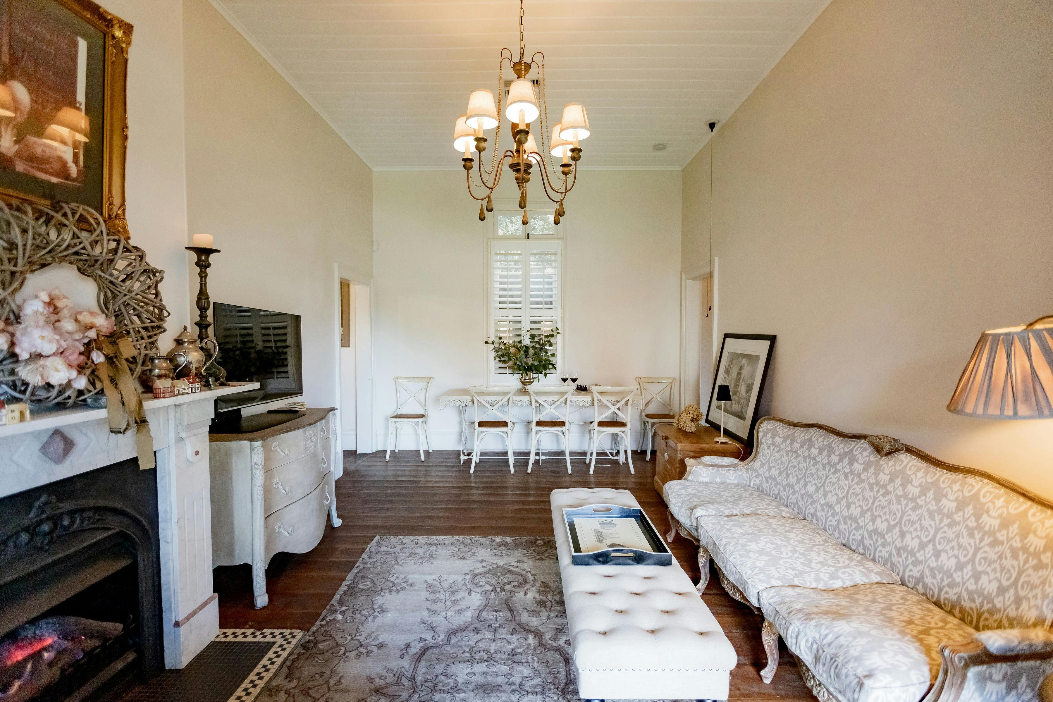 Living room with high ceilings, open fire, couch TV and dining table