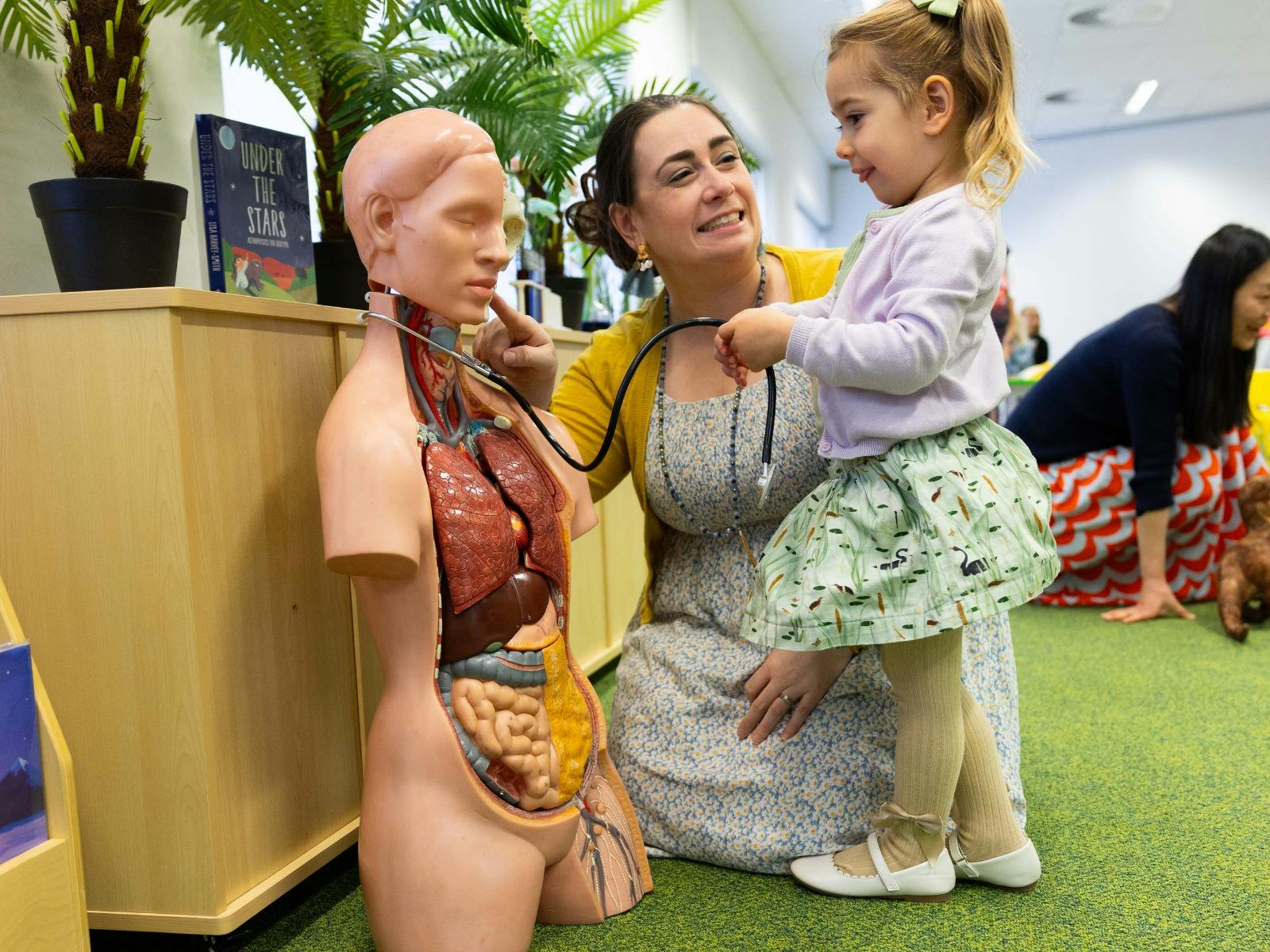 A young girl and woman exploring a human dummy