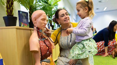 A young girl and woman exploring a human dummy