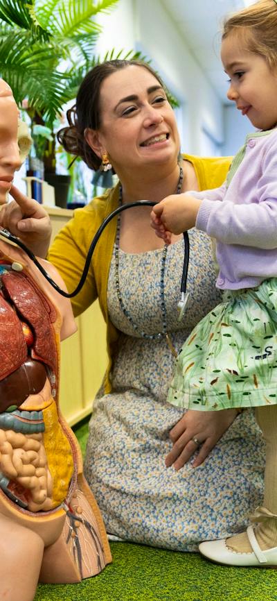 A young girl and woman exploring a human dummy