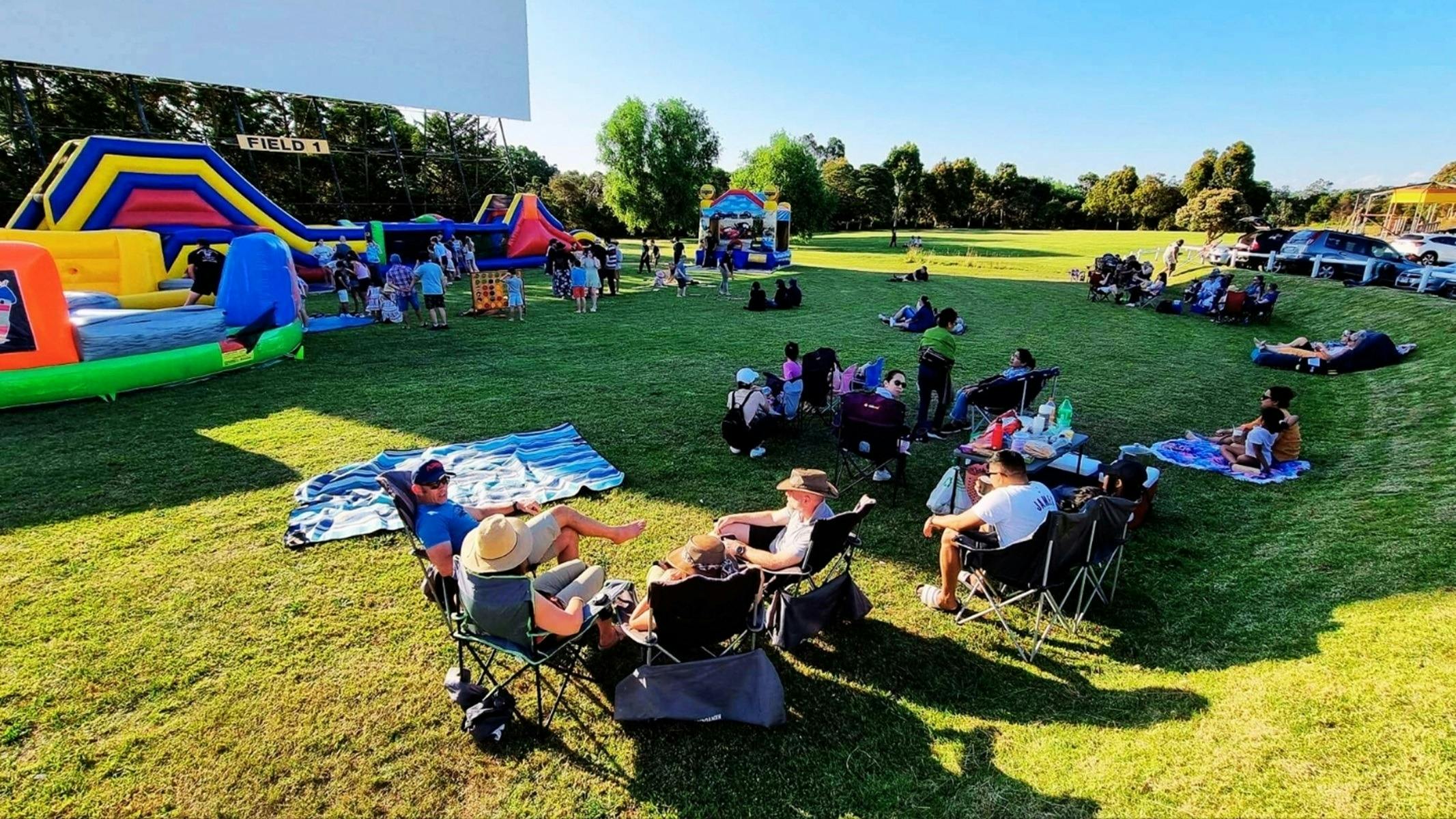 People sitting outside on the lawn talking and playing lawn games