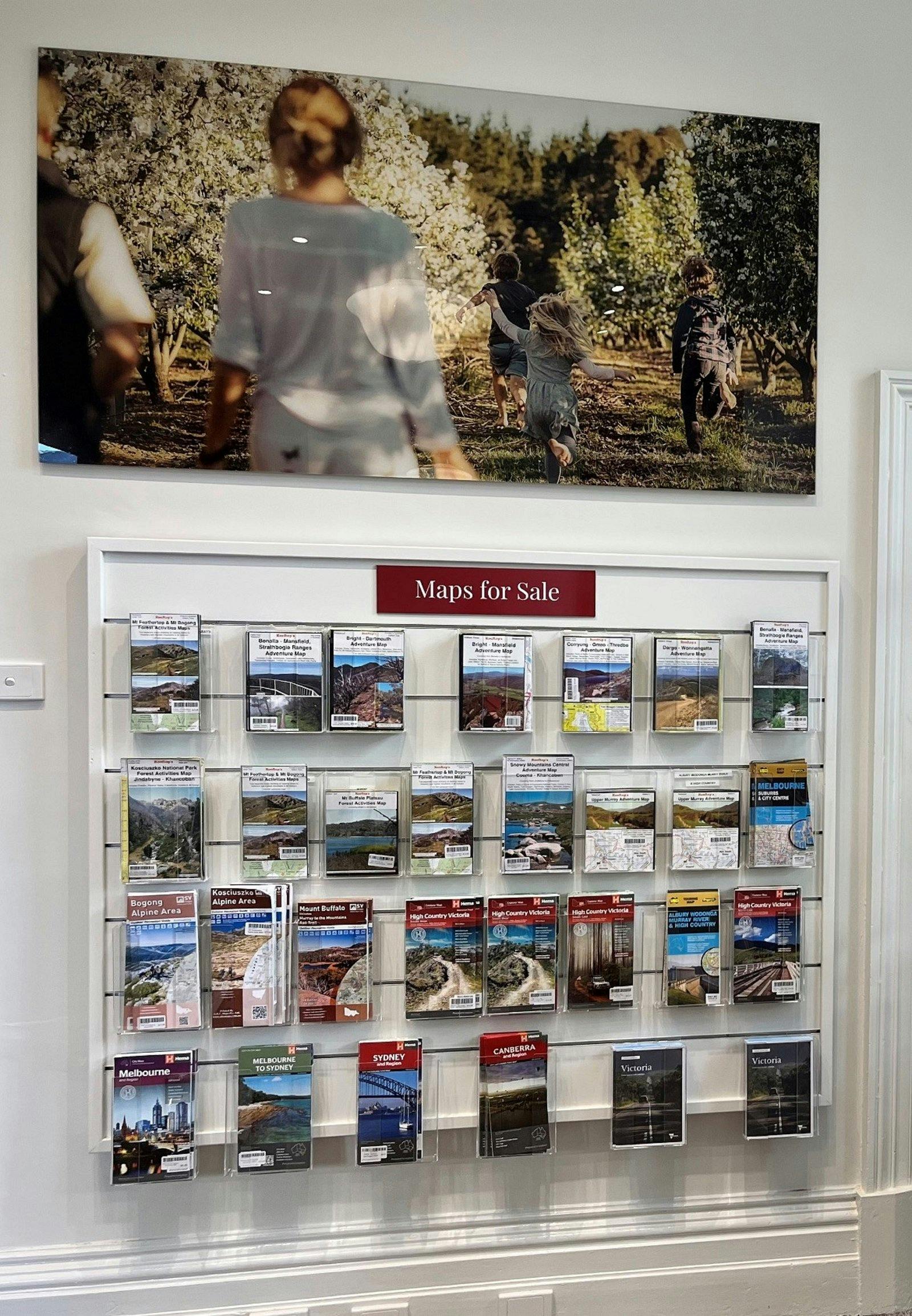 various maps for sale, displayed on the wall in clear racks