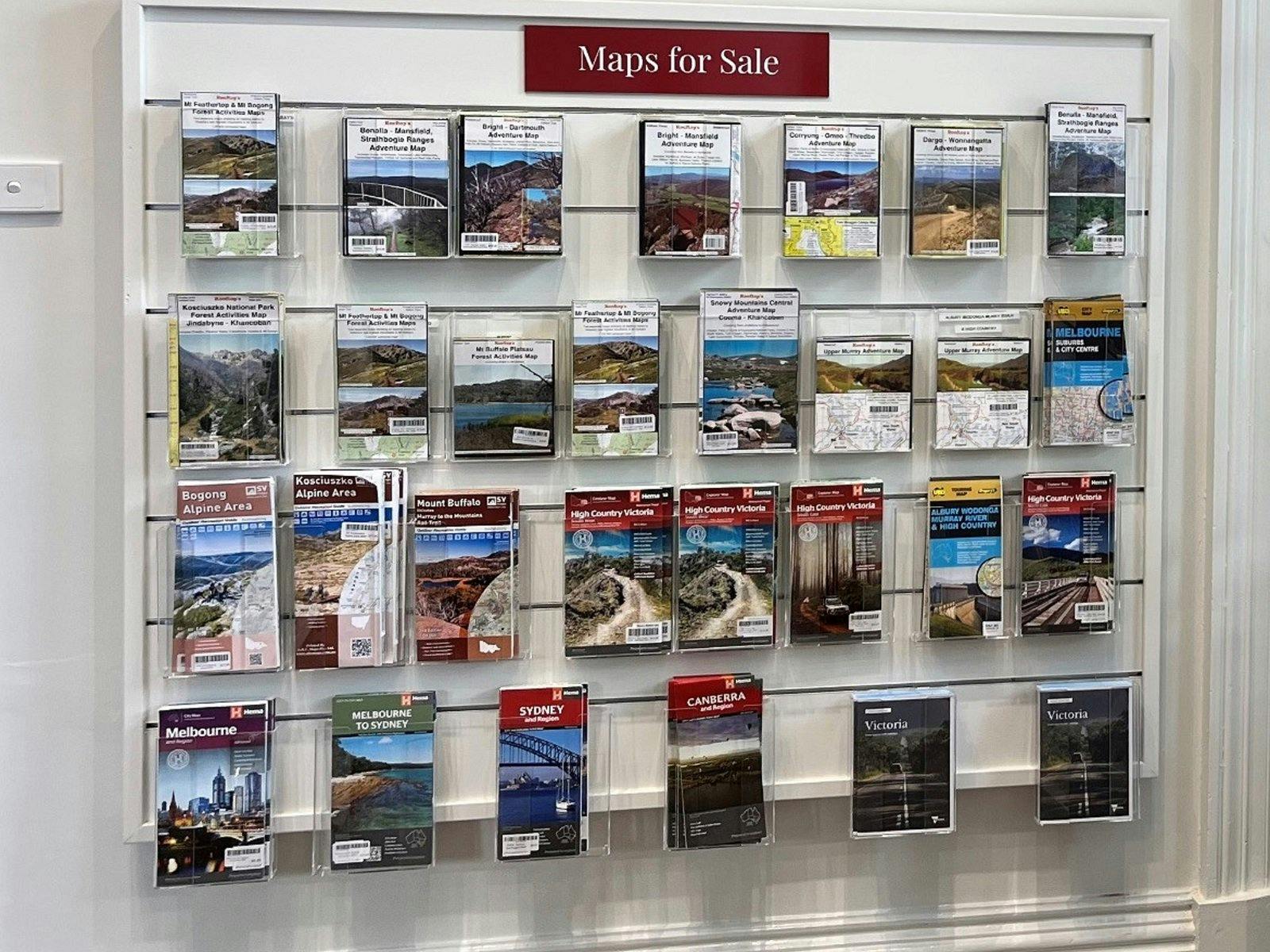 various maps for sale, displayed on the wall in clear racks