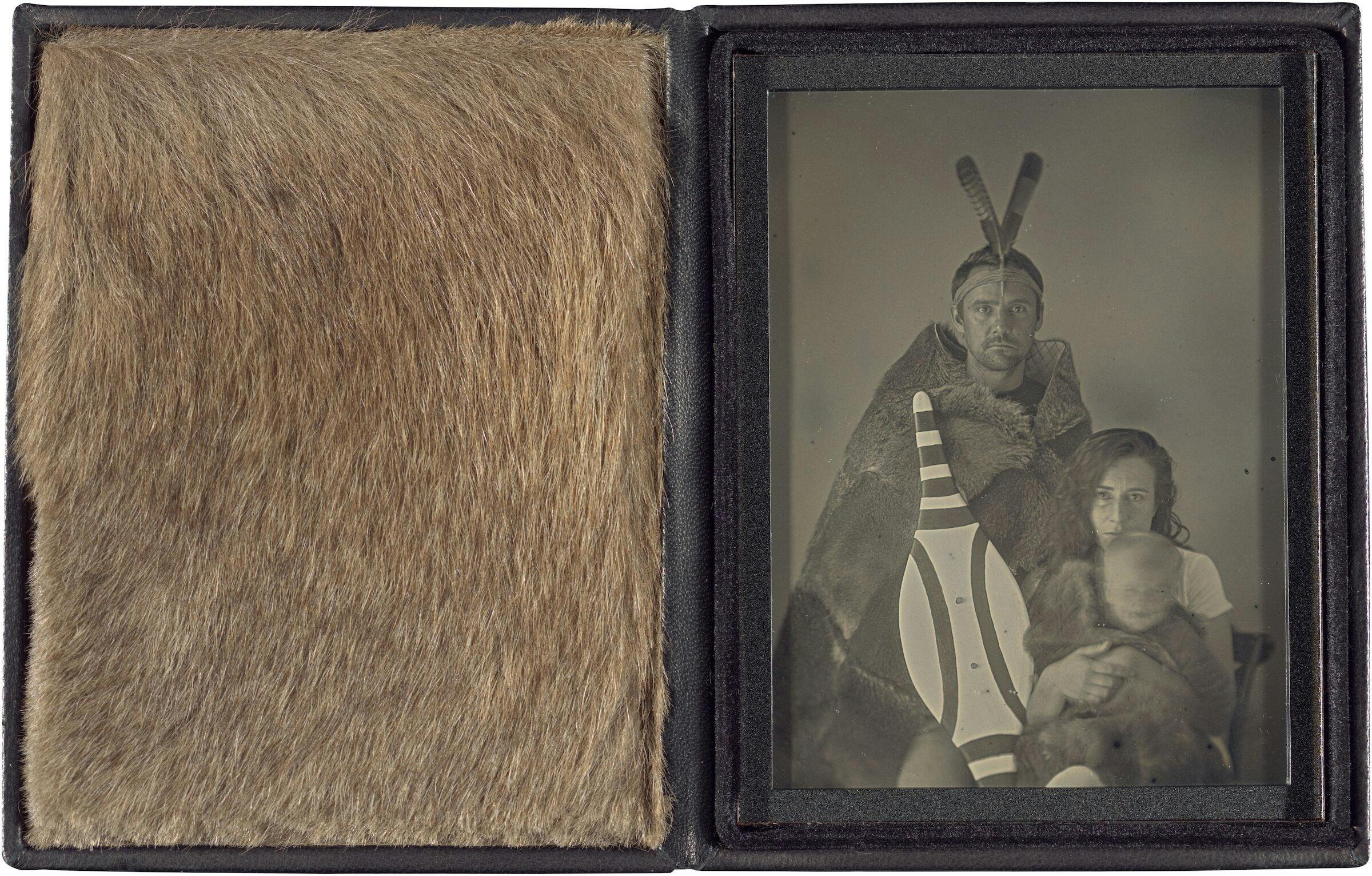 A leather case displaying Grey Kangaroo fur beside a greyscale photograph of a family.