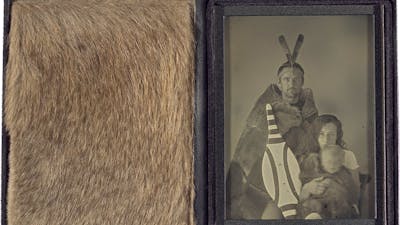 A leather case displaying Grey Kangaroo fur beside a greyscale photograph of a family.
