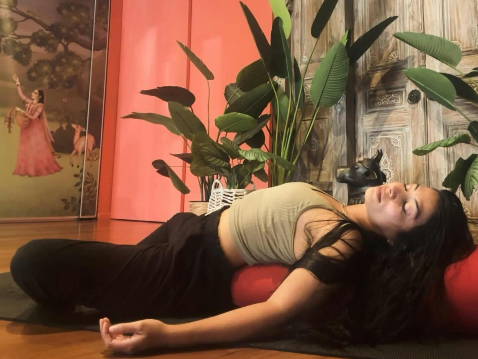 Woman lying down, relaxing on a yoga bolster