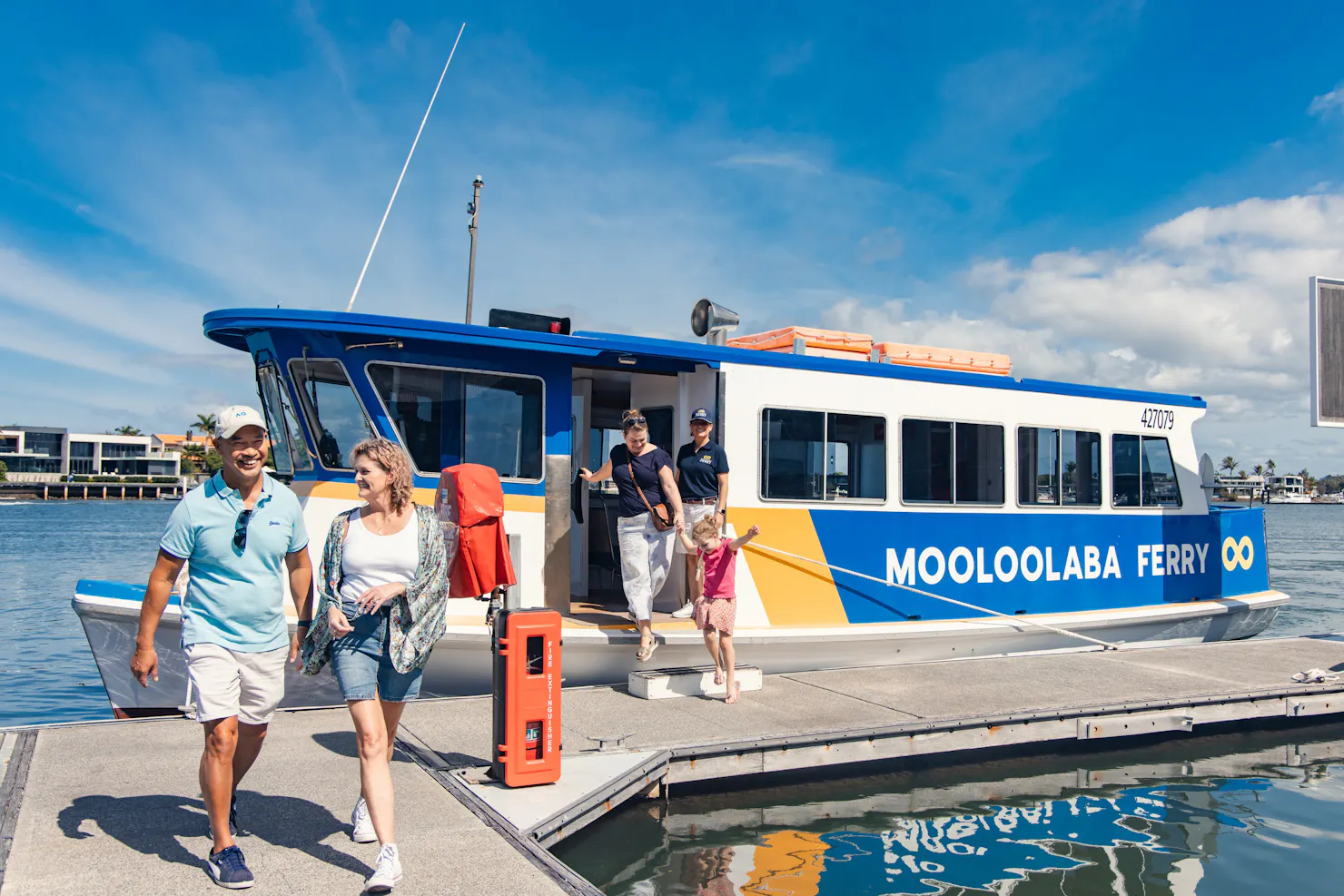 A ferry standing by the dock with passengers disembarking.