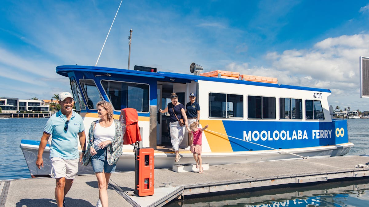 A ferry standing by the dock with passengers disembarking. A ferry standing by the dock with passengers disembarking.