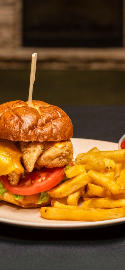 Buttermilk soaked chicken tenders, lettuce, tomato, cheese, tangy burger sauce on a pretzel bun