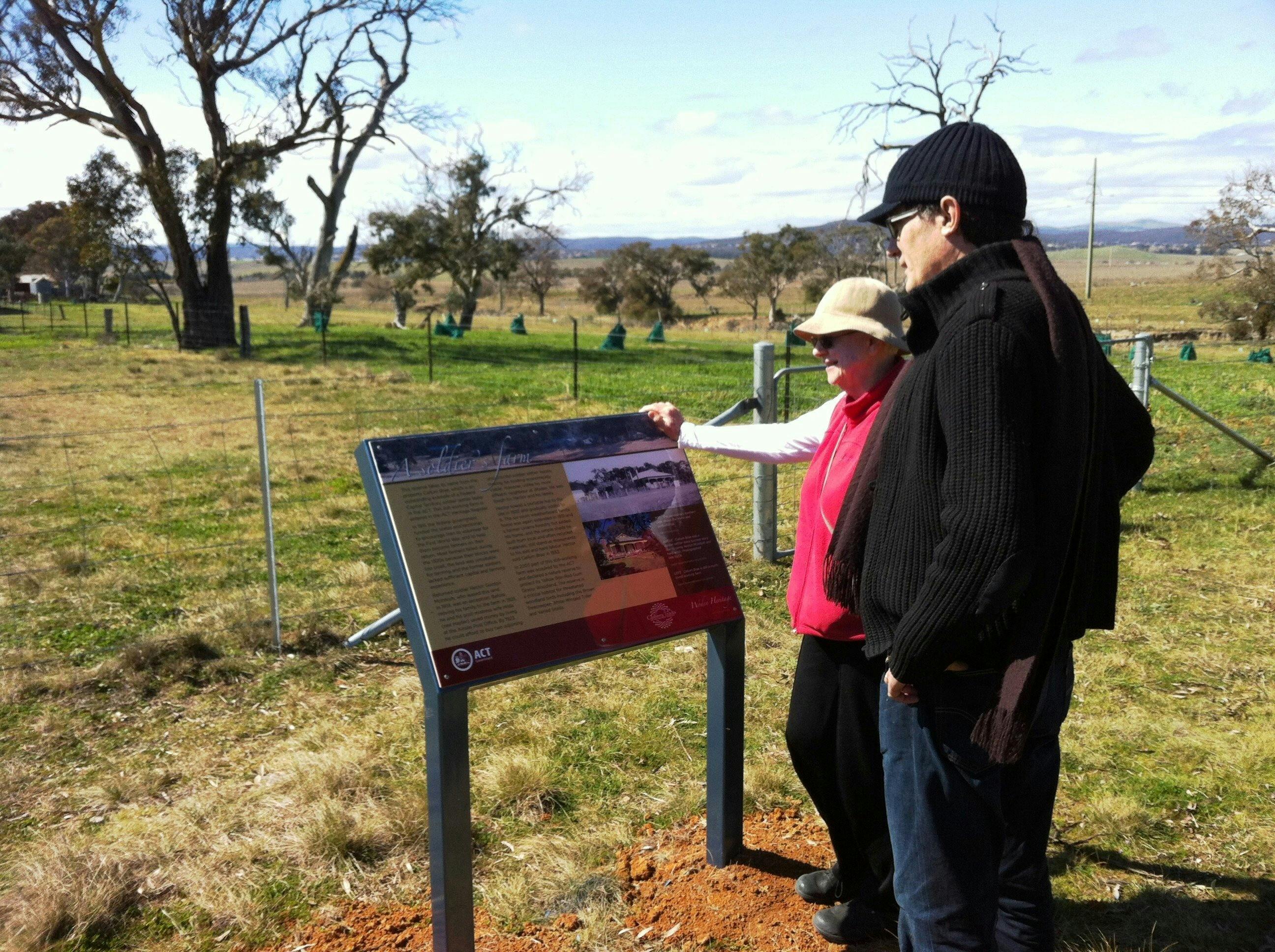 A couple viewing an information panel in farmland