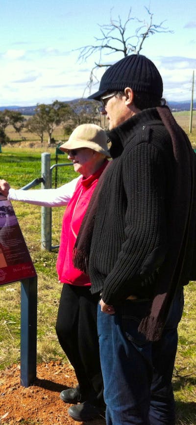 A couple viewing an information panel in farmland