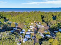 Image showing a full Resort with Caravans, Camping and Motorhomes from above. Beach in the distance