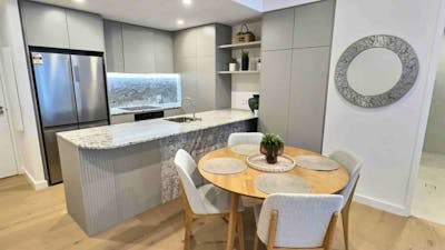 Close-up of a kitchen island counter paired with a wooden dining table setup.