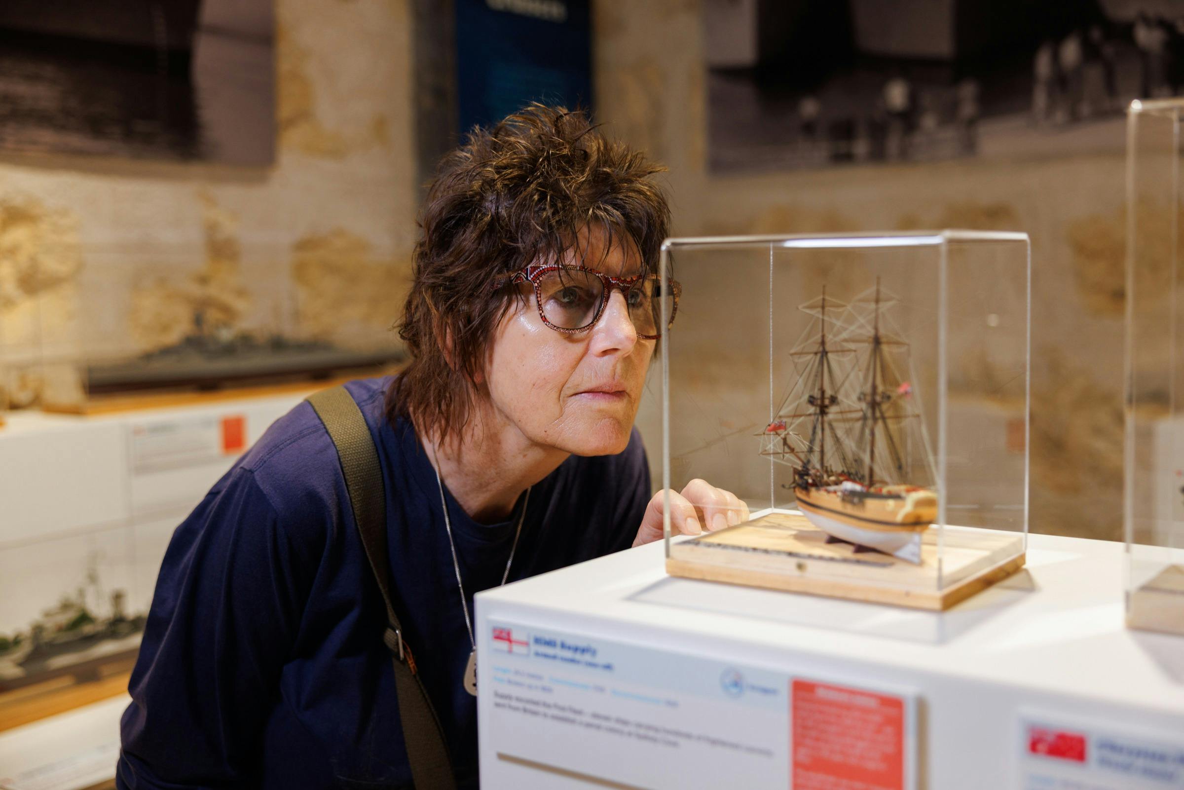 one person as a close up looking at a model ship very closely