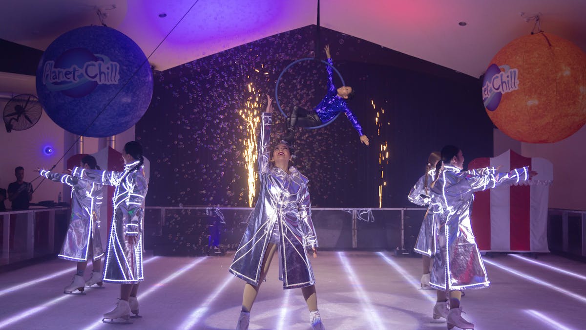 Cast of the ice-skating show wearing silver jackets Cast of the ice-skating show wearing silver jackets