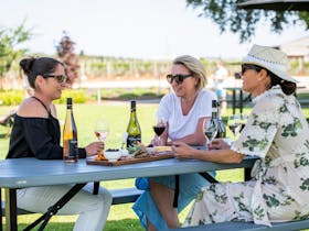 Customers enjoying a platter and glass of wine on our beautiful lawn.