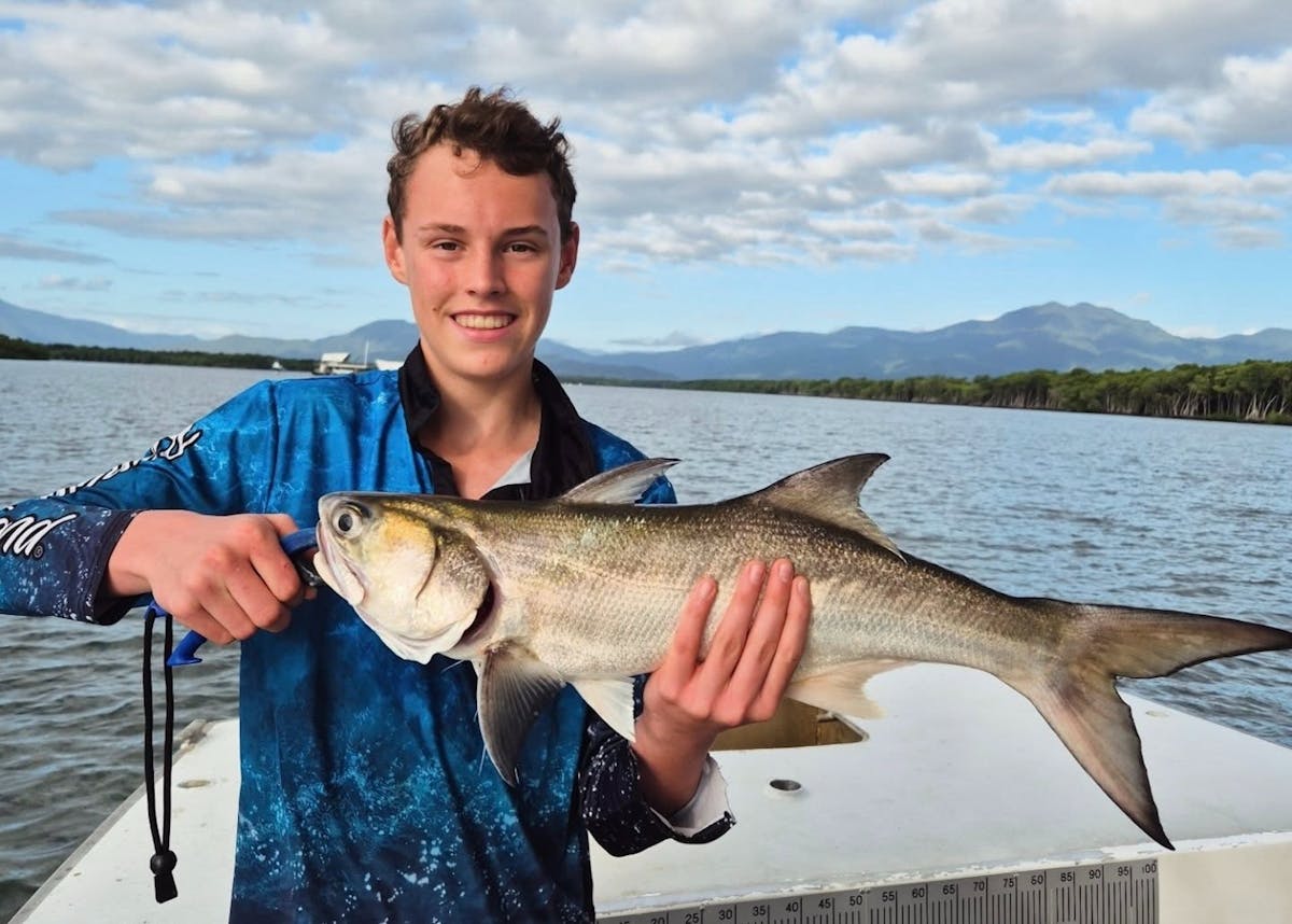 Young Cairns angler holding a salmon with Gone Fishing Cairns