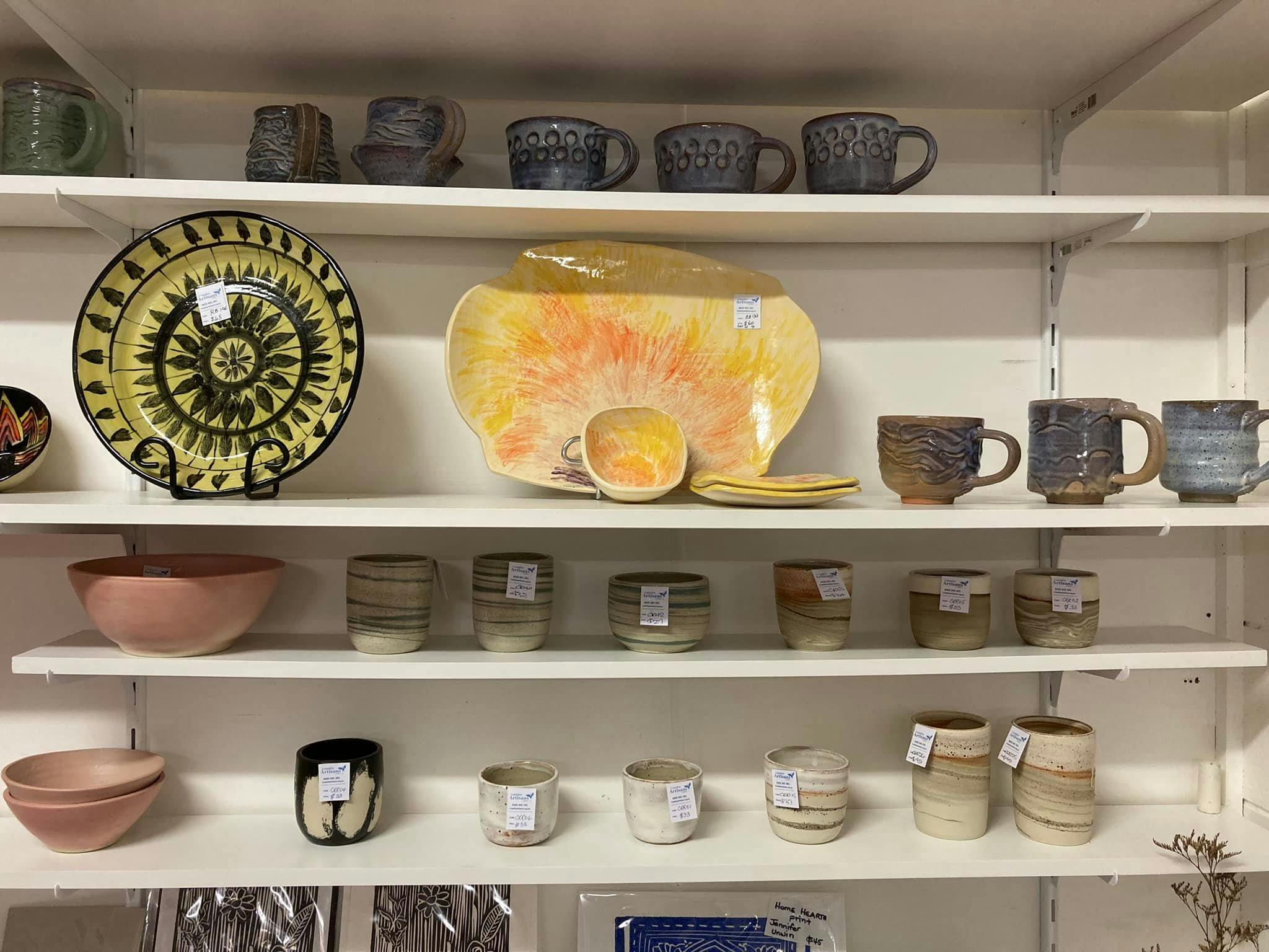 Ceramics on white shelves in the gallery
