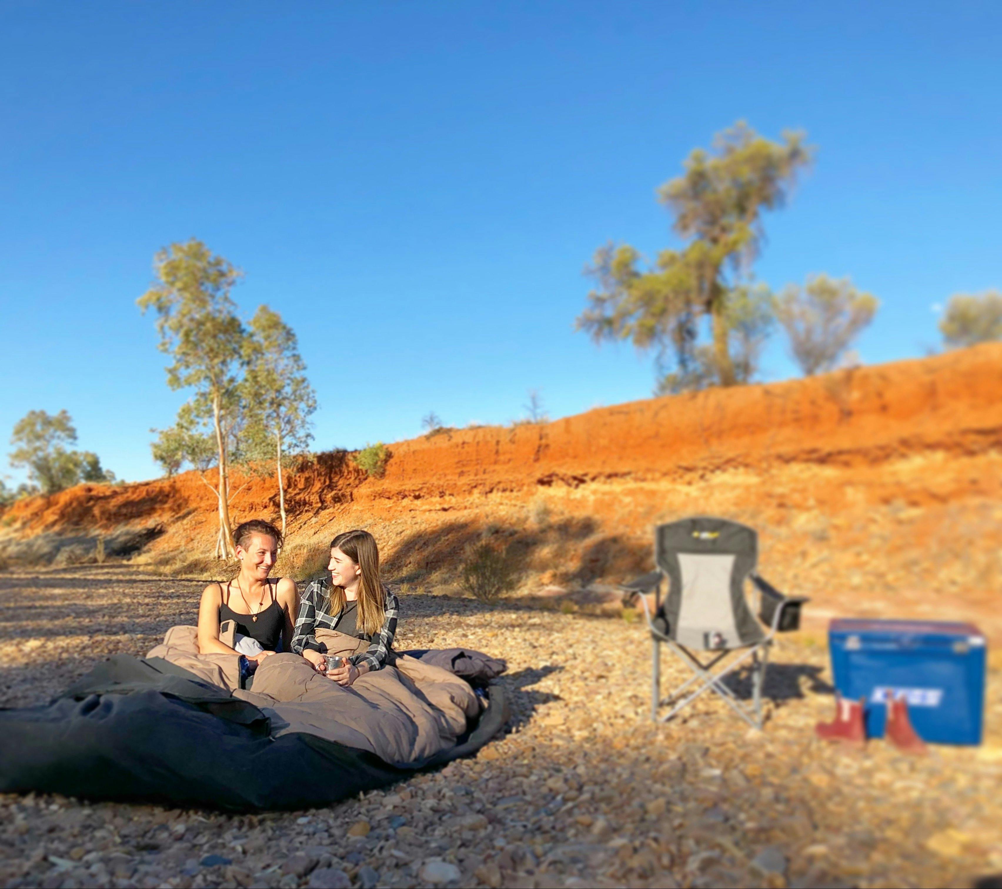 Two campers sharing a swag in a campsite at Redbank Waterhole