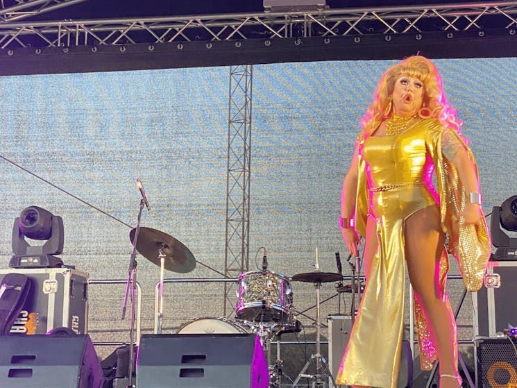 Drag performer on stage performing at Rainbow on the Plains Festival