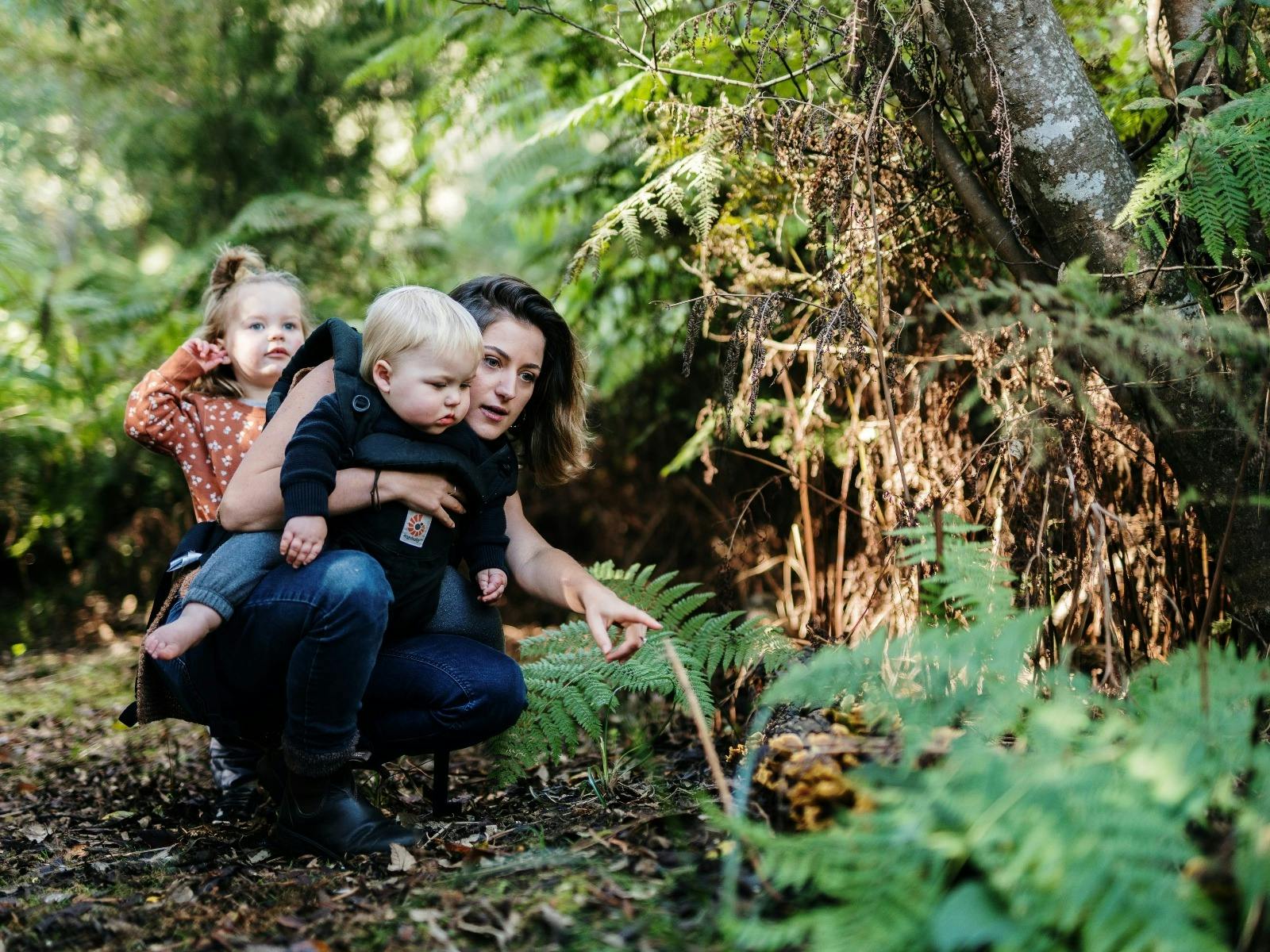 Mother and children exploring flora in Leven Park.