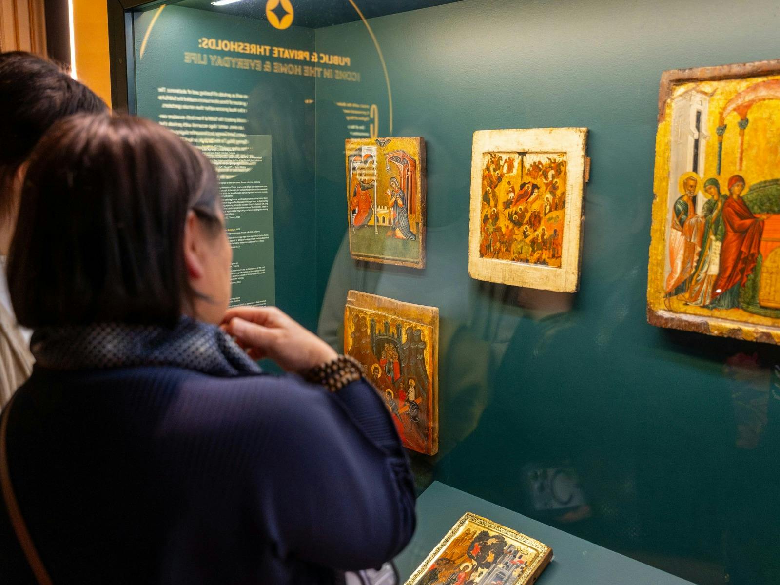 Woman looking at iconography featured in exhibition