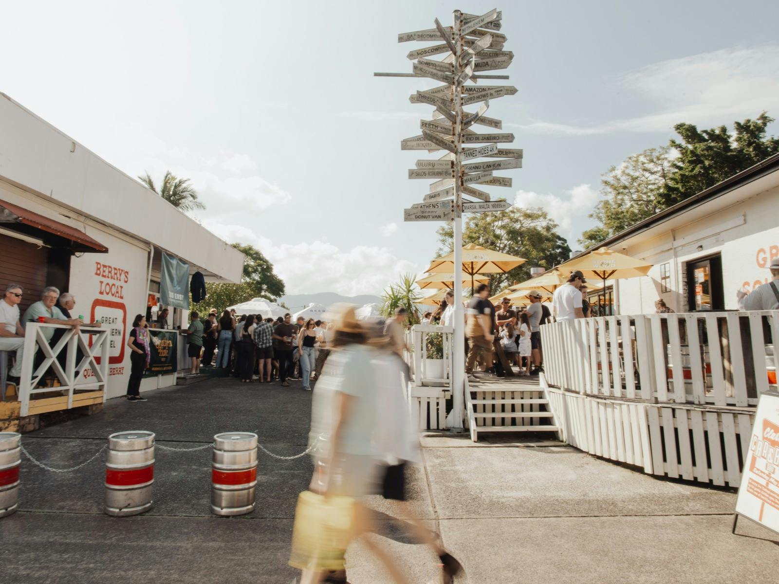 People gathered in the outdoor courtyard at Great Southern Hotel Berry with yellow umbrellas and a t