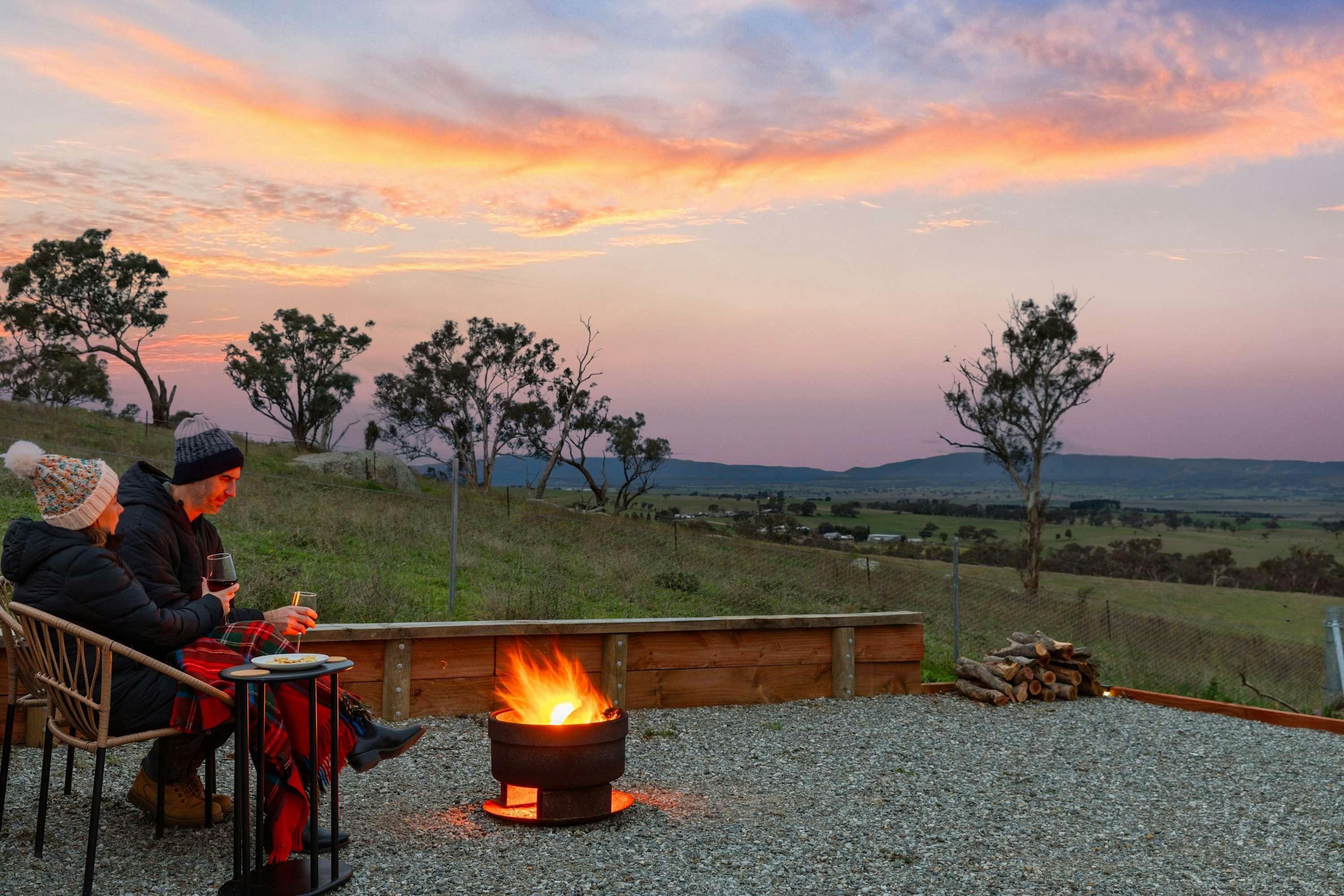 Couple enjoying a blaring fire pit with amazing regional views