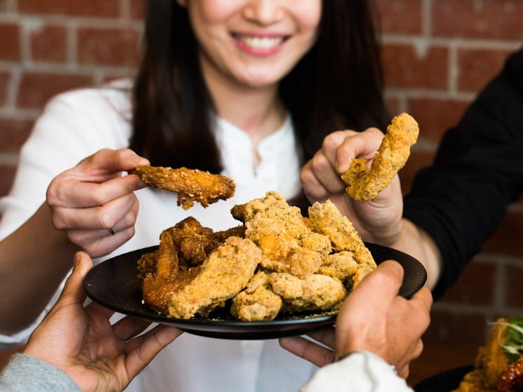 Girl holding a piece of korean fried chicken
