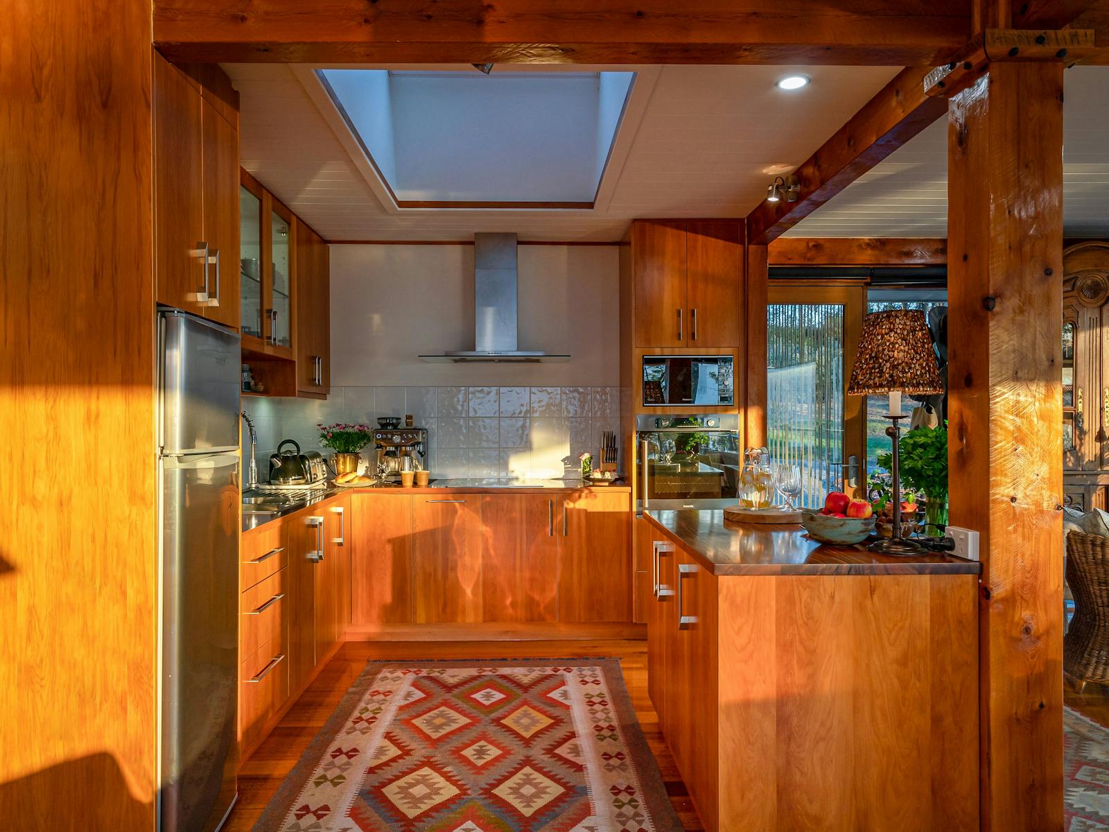 A photo of the Huon River Hideaway kitchen featuring custom timber cabinetry and ample appliances