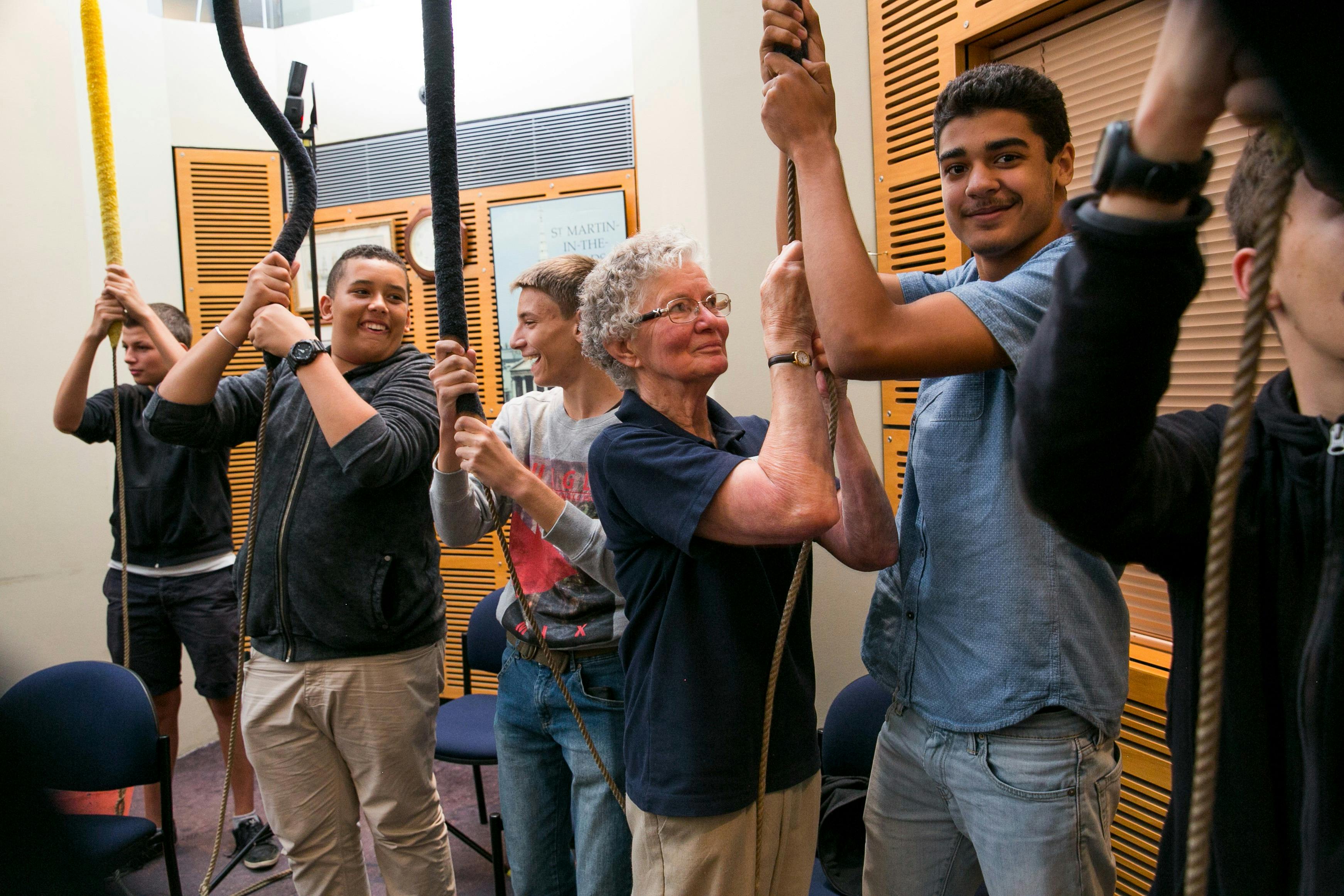 A tou guide helps a group chime a bell