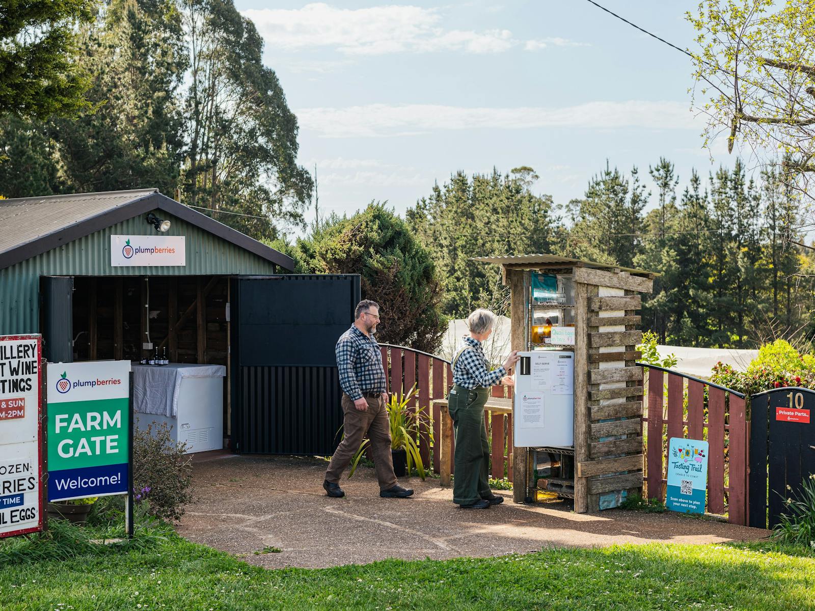 farm gate shed and self-serve station with two people