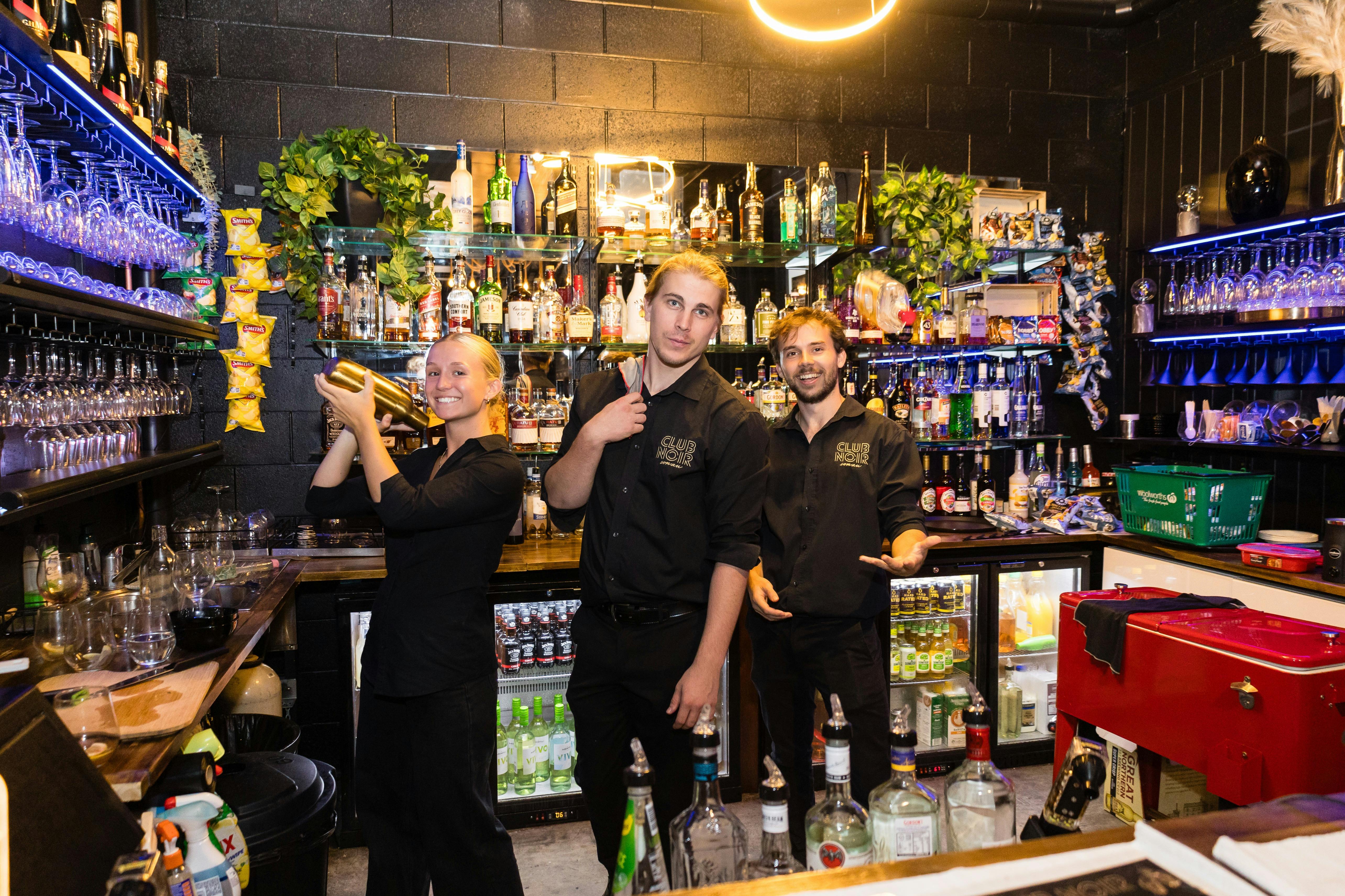 Club Noir Staff posing behind bar