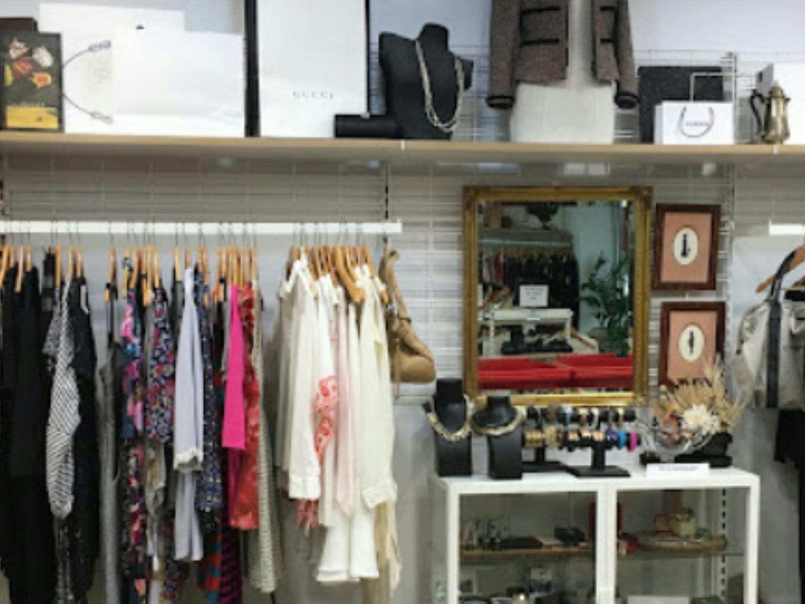 Image of clothing on a rack, bric-a-brac, jewellery and other items for sale