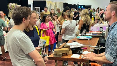 Couples talking with exhibitors at Your Local Wedding Guide Canberra Expo.