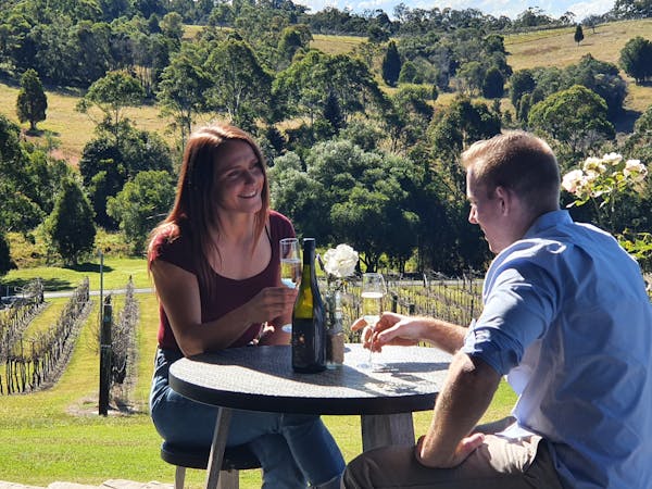 couple sipping wine with winery backdrop