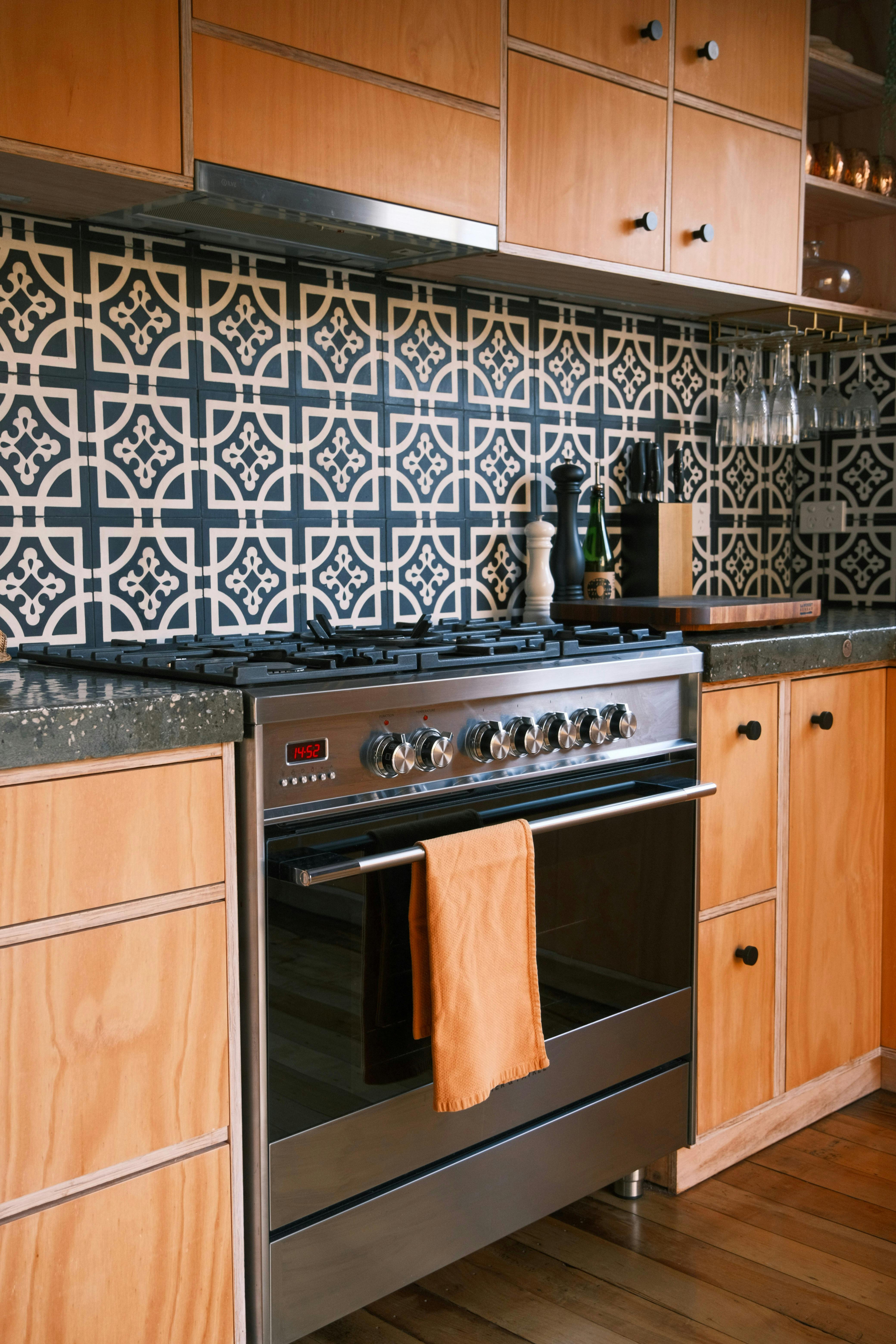 Gas stove, black and white mosaic tiles in a timber kitchen