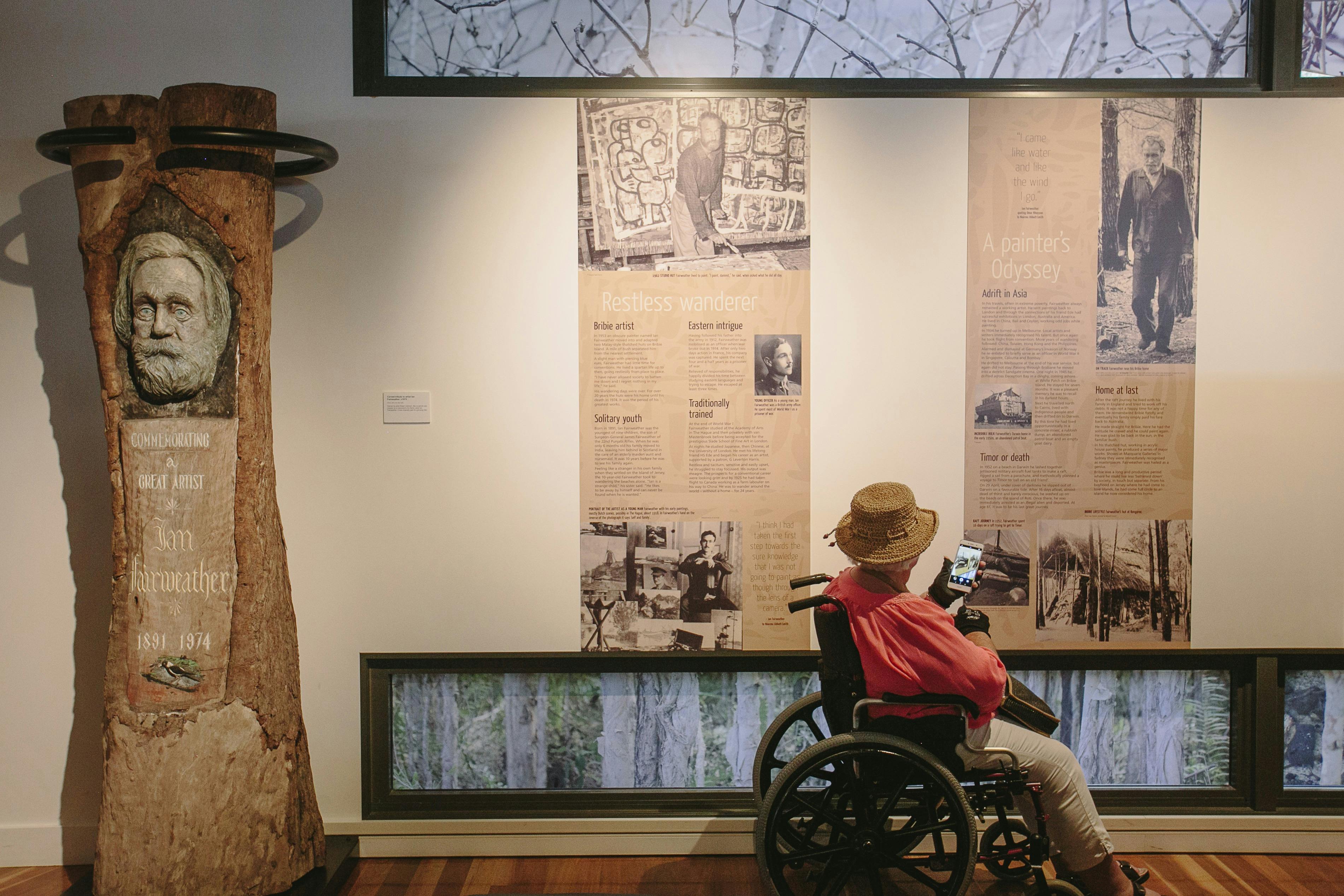 Woman in wheelchair viewing Fairweather exhibition