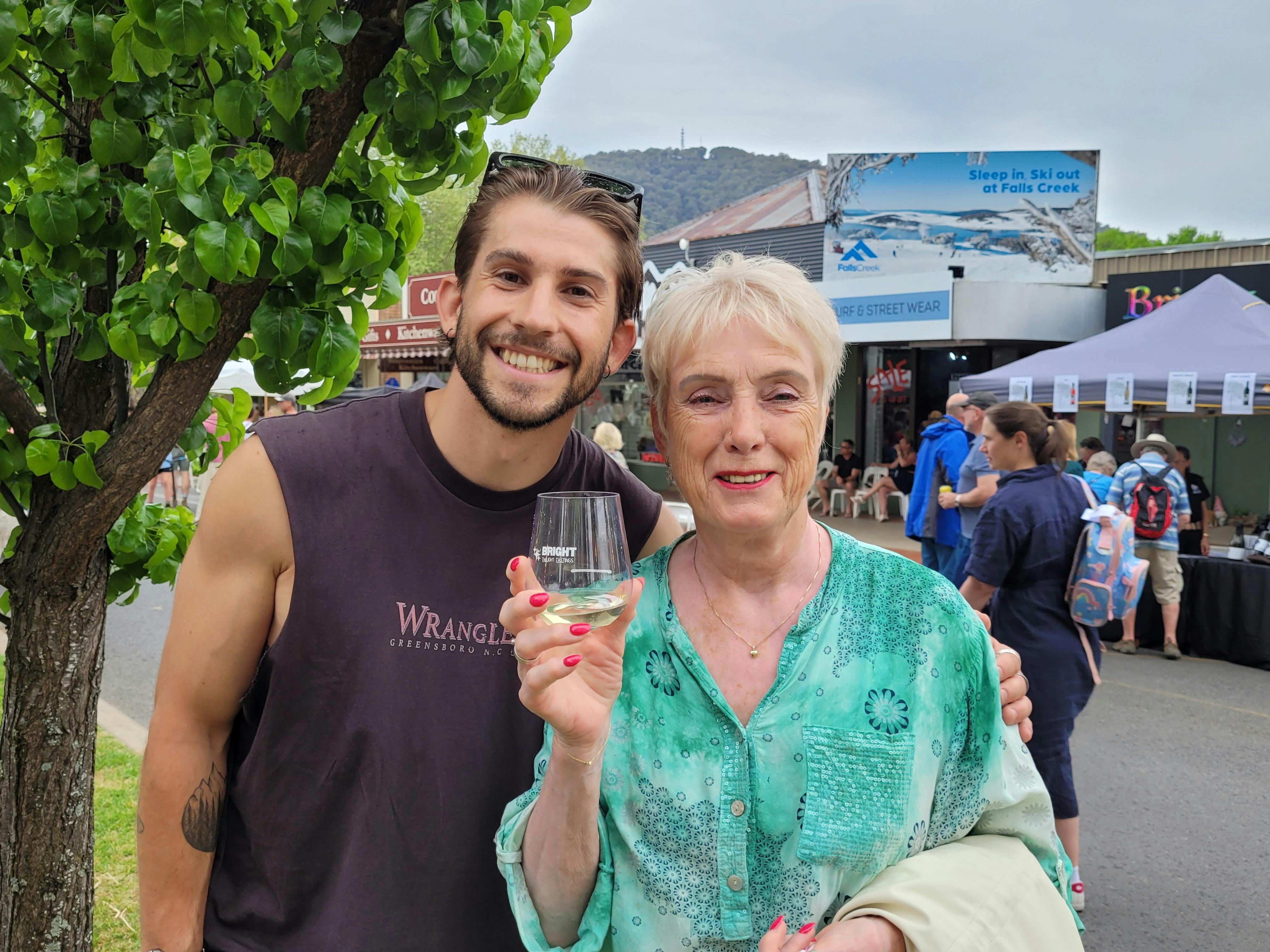 two people smiling and holding wine